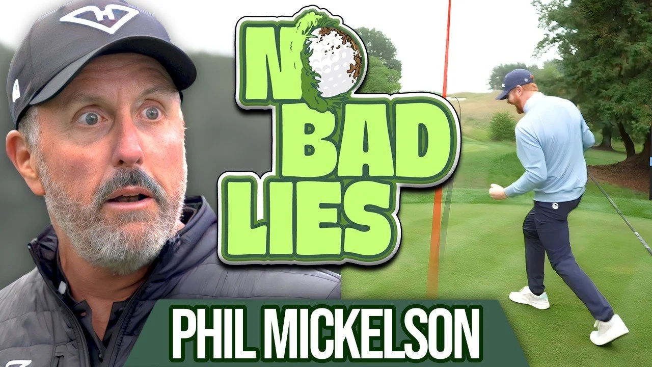 A man in a blue jacket and cap is playing golf on a green course, preparing to hit a golf ball; a large graphic text overlay reads 'No Bad Lies' with a golf ball graphic, and below it says 'Phil Mickelson'.