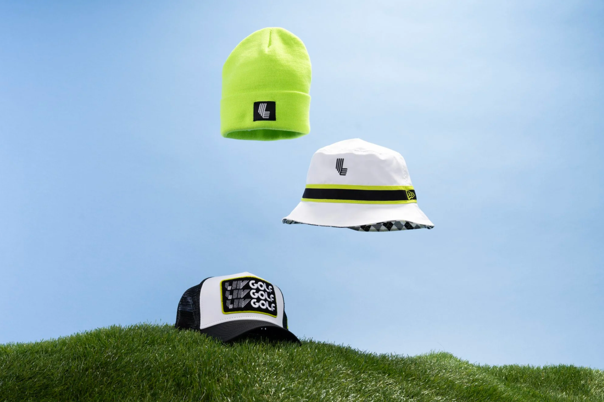 Various golf hats with different designs and logos, placed on a grassy surface, with a blue sky background.
