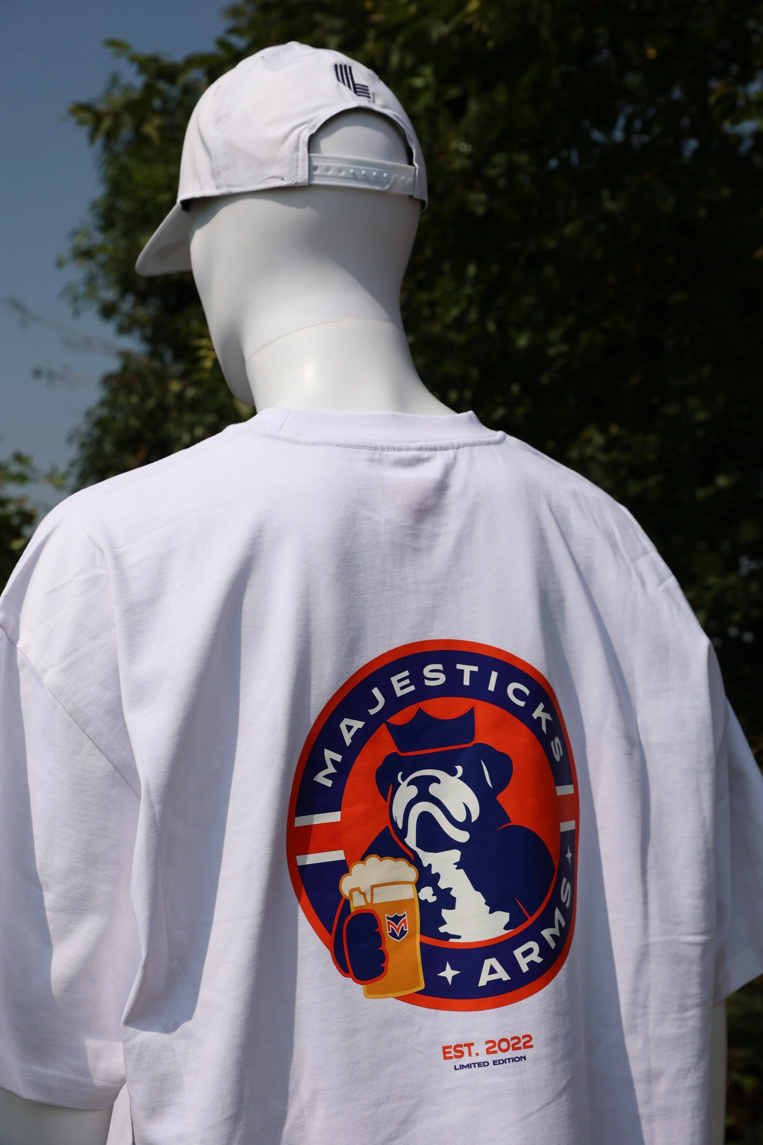 Back of a white mannequin wearing a white baseball cap and a white T-shirt with a logo that says 'Martjesticks Army,' featuring a dog's head, a beer mug, and the text 'EST. 2022' and 'Limited Edition'.