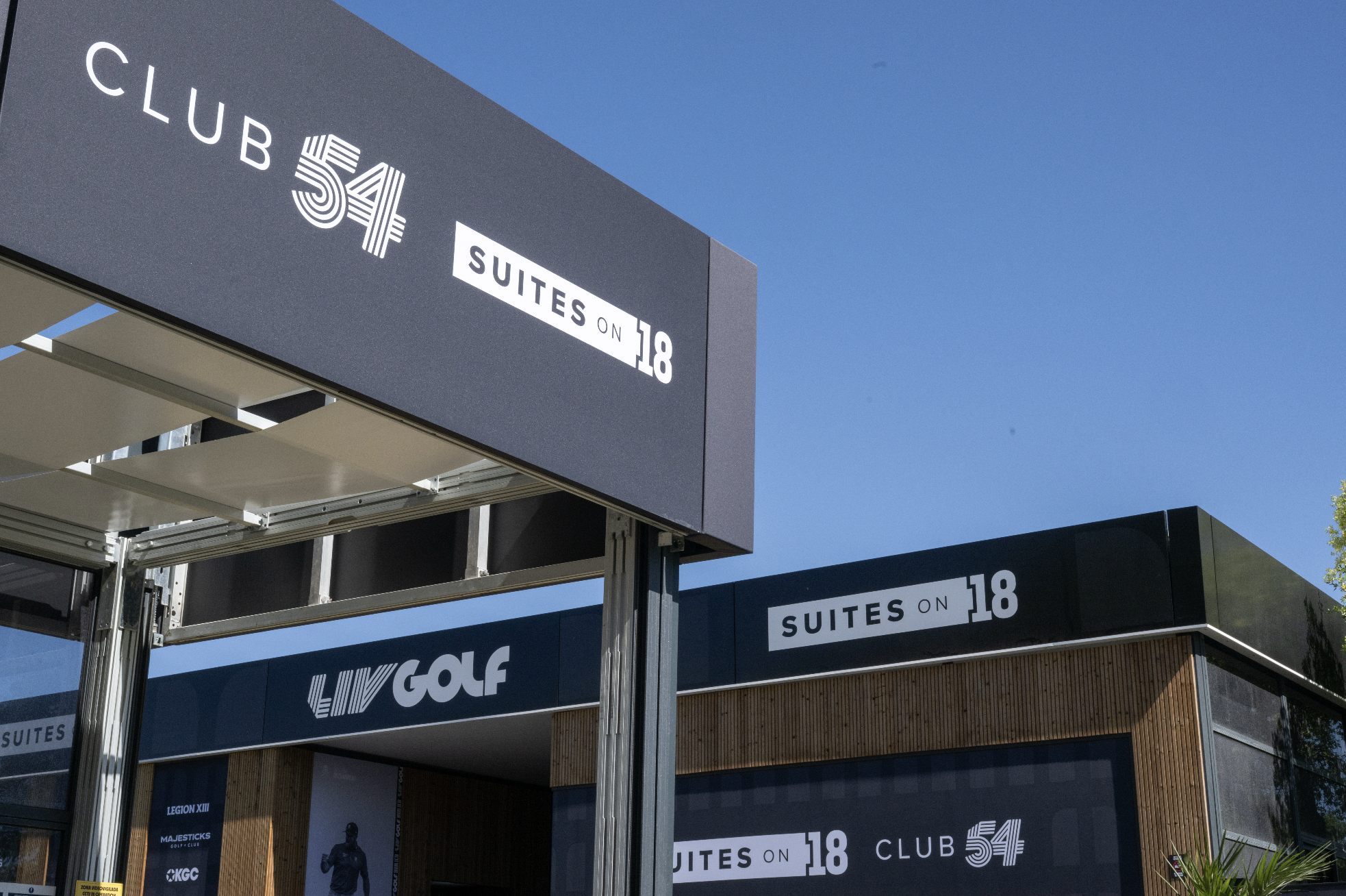 Signboard for Club 54 at Suites on 18, with clear blue sky in the background.