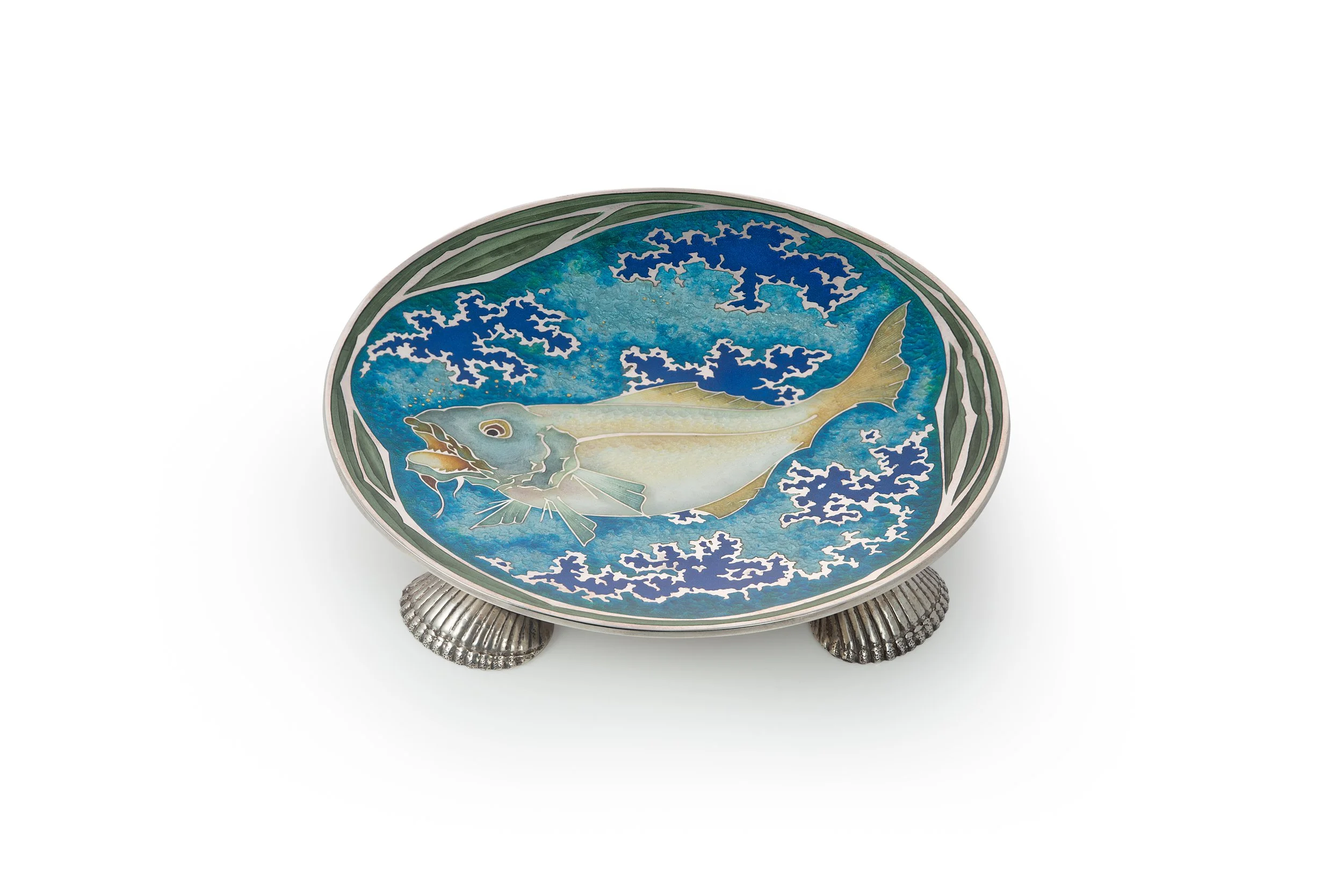 A decorative plate with a fish and ocean wave pattern, supported by a silver-colored stand with a textured design.