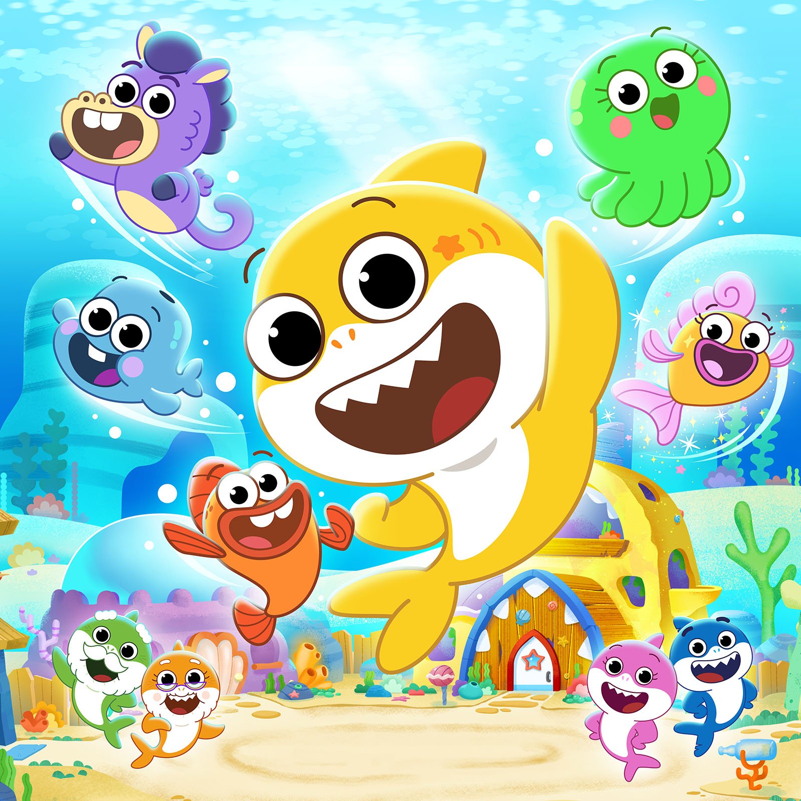 Colorful cartoon underwater scene featuring a happy yellow dolphin and various cheerful sea creatures including a purple seahorse, green octopus, blue fish, orange fish, pink fish, and other aquatic animals all smiling and playing near a sea cave with coral and plants in the background.