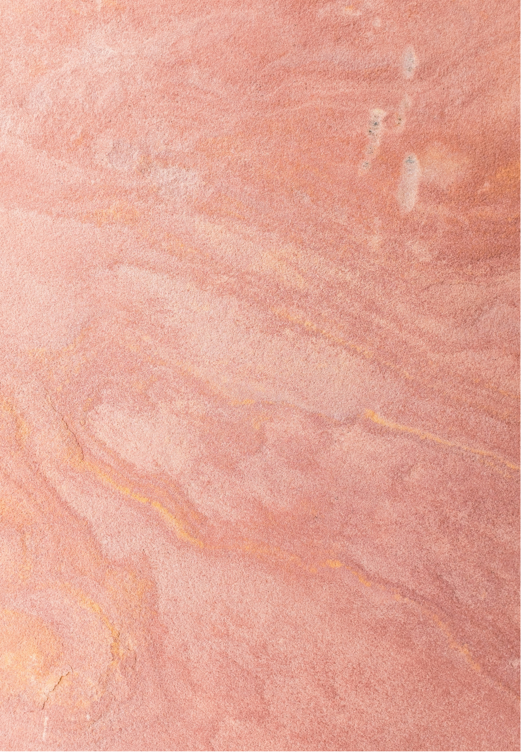 Close-up of a pinkish-orange textured surface, possibly a wall or paper, with visible cracks and subtle color variations.