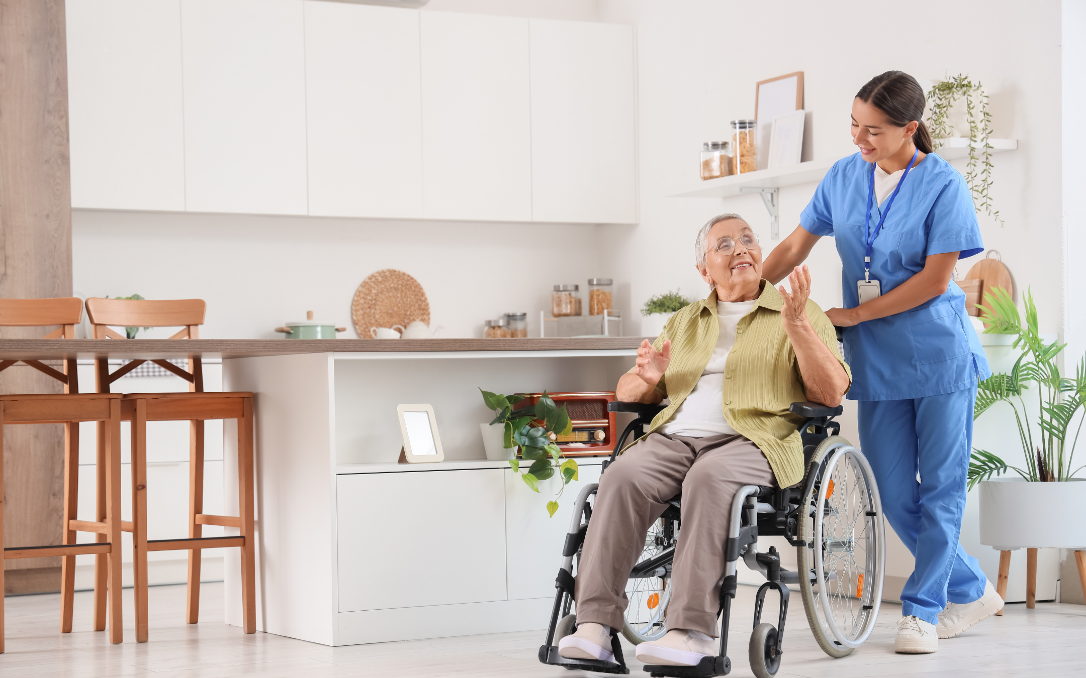 Senior woman in wheelchair navigating accessible kitchen layout with caregiver assistance representing mobility renovation modifications by Melesh Construction Dallas
