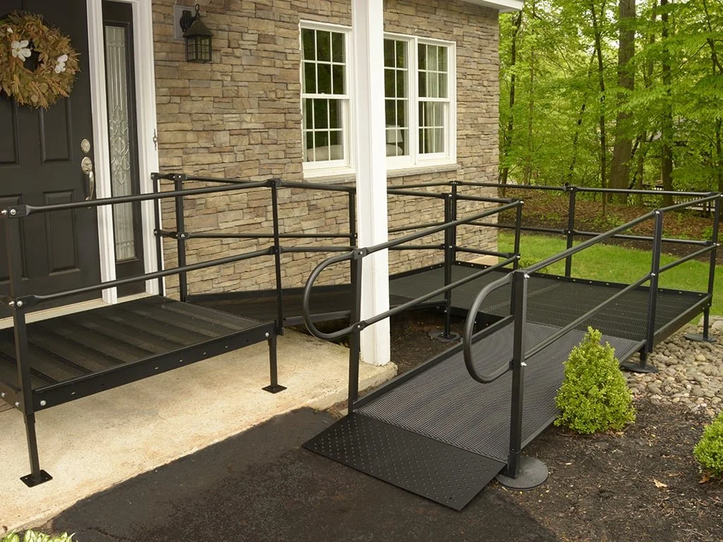 Residential wheelchair accessibility ramp with metal handrails, landing platform, and non-slip surface installed at home entry by Melesh Construction Dallas serving the DFW Metroplex