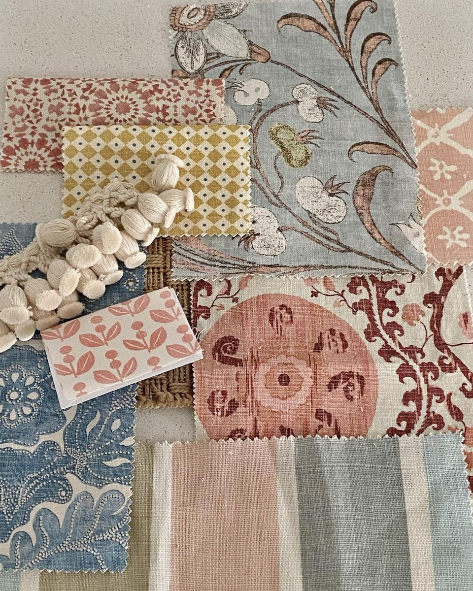 Samples of fabric swatches in various colors and patterns, with some small cotton balls and a pink and peach leaf-patterned sticker on top.