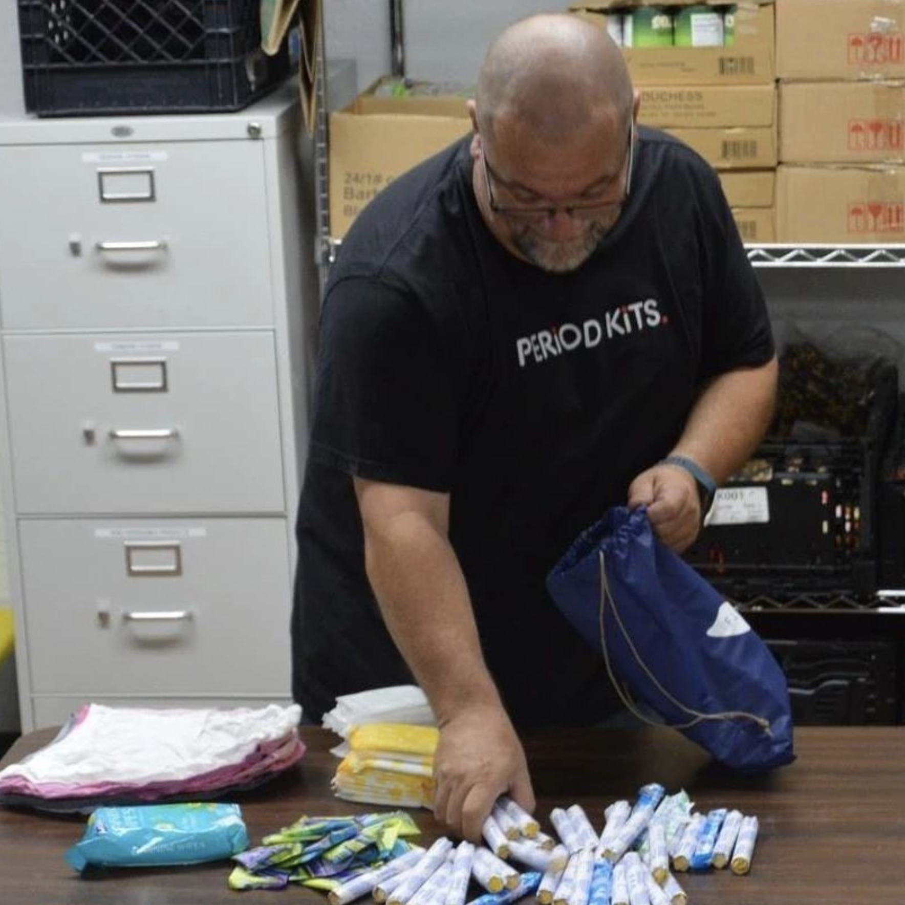 A man sorting period products on a desk