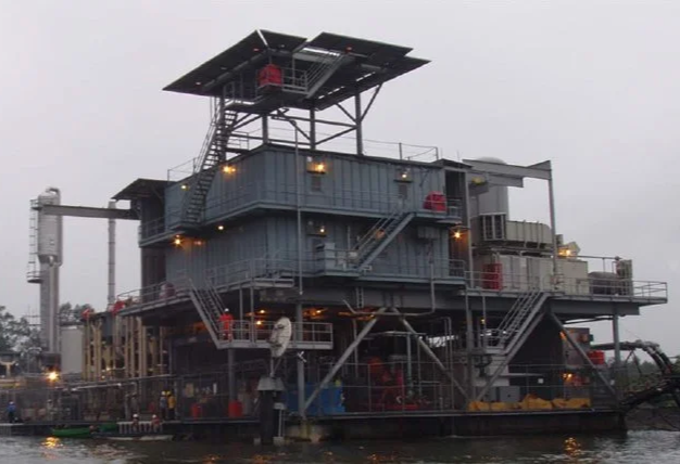 Off-shore oil facility with industrial pumping and automated controls.