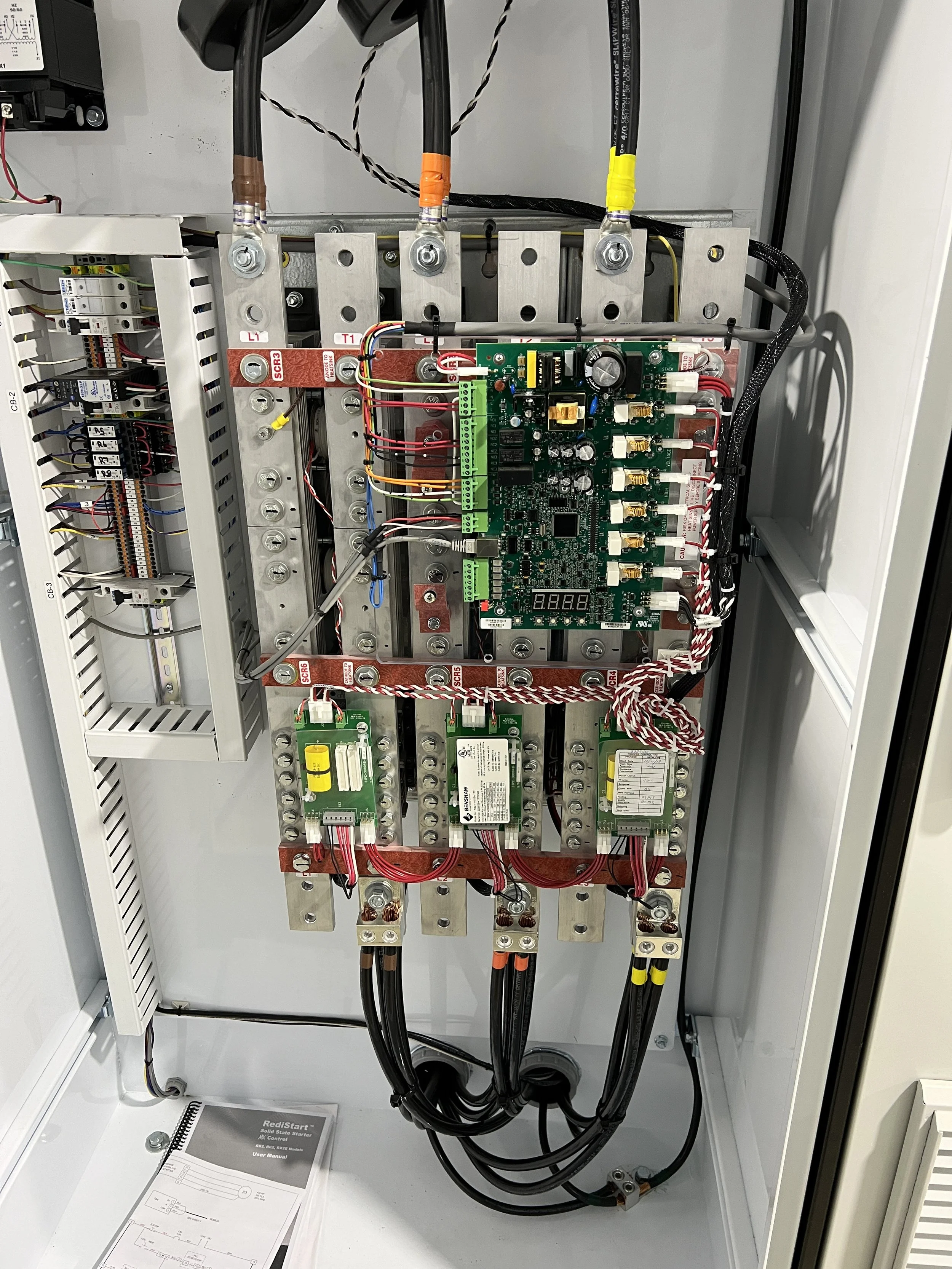 Clean and organized electrical motor control panel with a soft-starter.