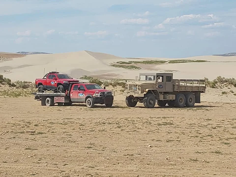 Tow Truck with small truck on deck along with army 5ton