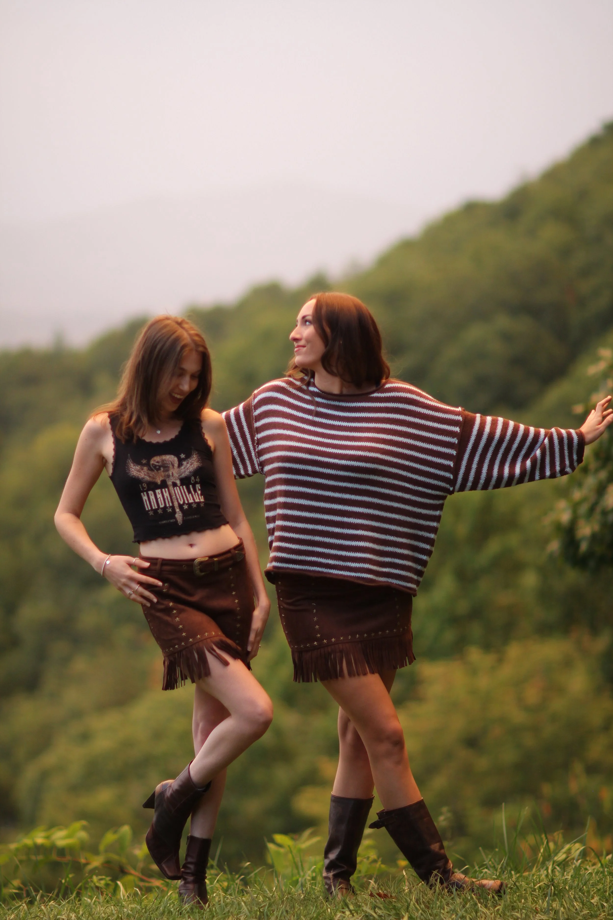Woman wearing the Fireside Stripe Sweater with denim jeans, walking outdoors on a mountain trail
