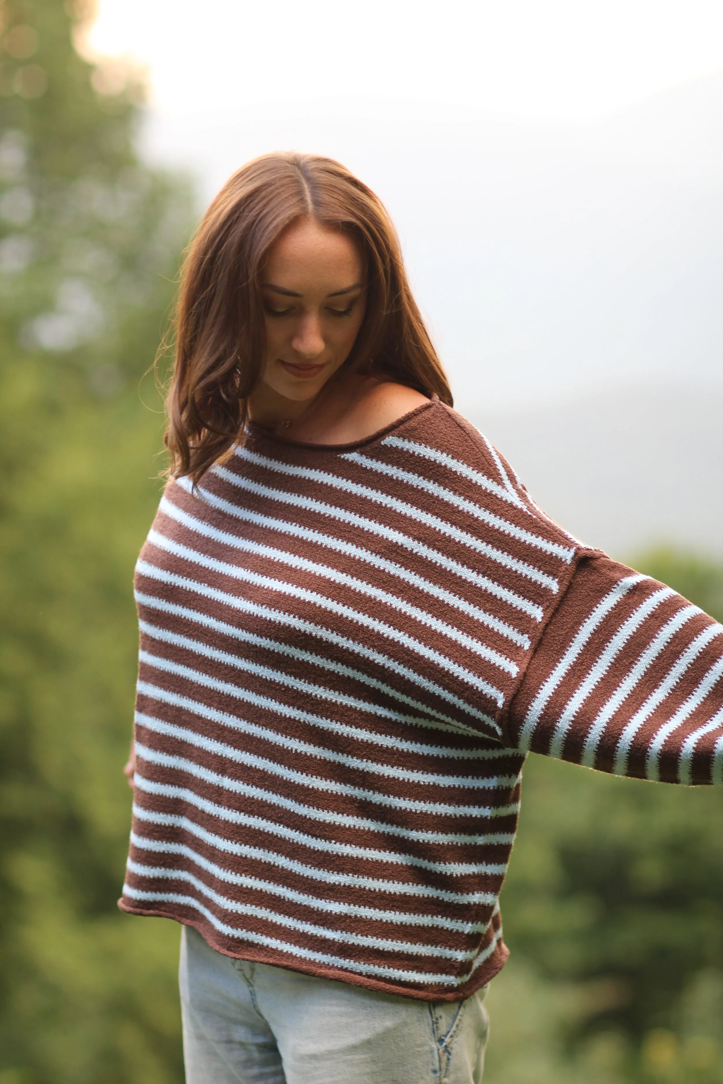 Woman posing outdoors in the Fireside Stripe Sweater, three-quarter body view