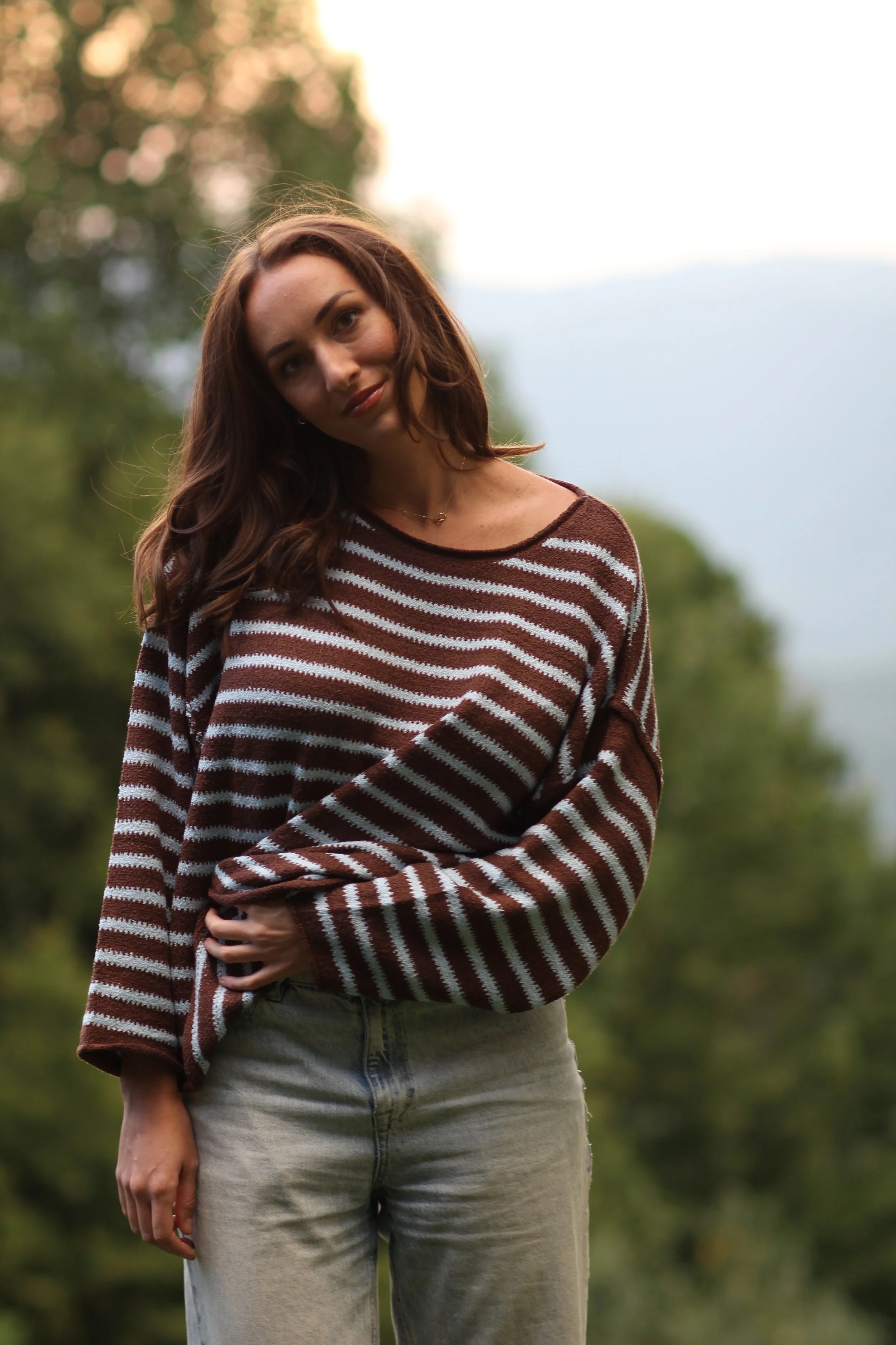 Woman wearing the Fireside Stripe Sweater in brown and cream knit, close-up front view