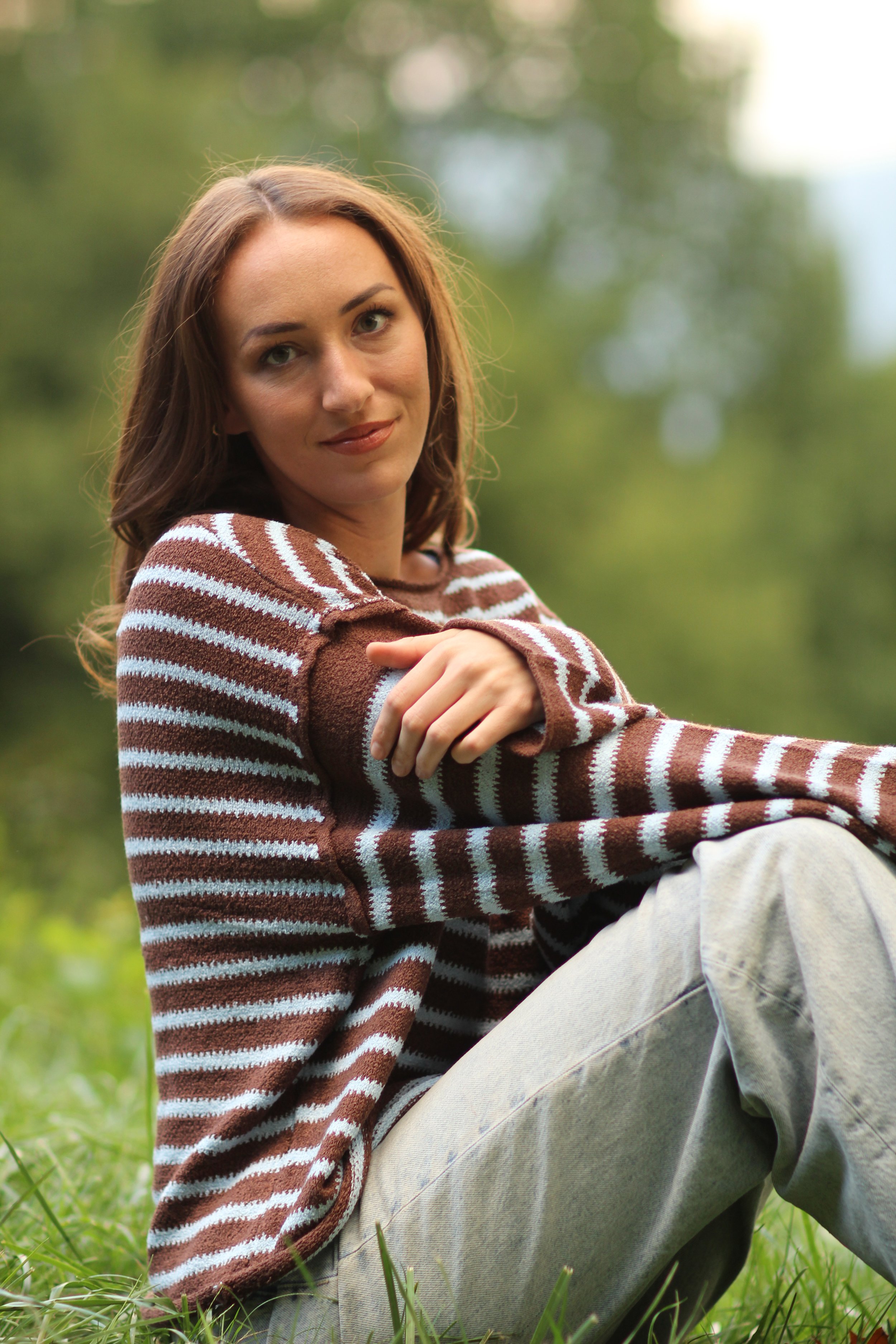 Candid close-up of woman laughing while wearing the Fireside Stripe Sweater outdoors