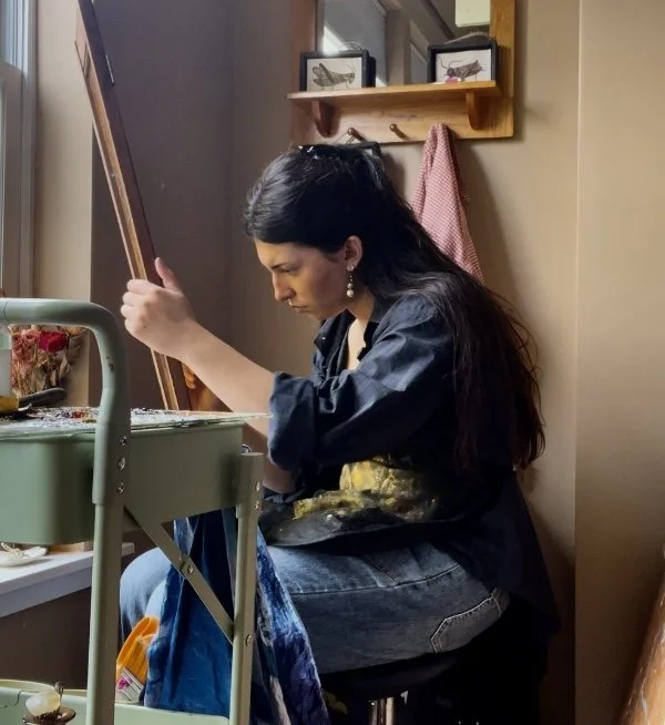 Woman painting at an art station in a cozy room.