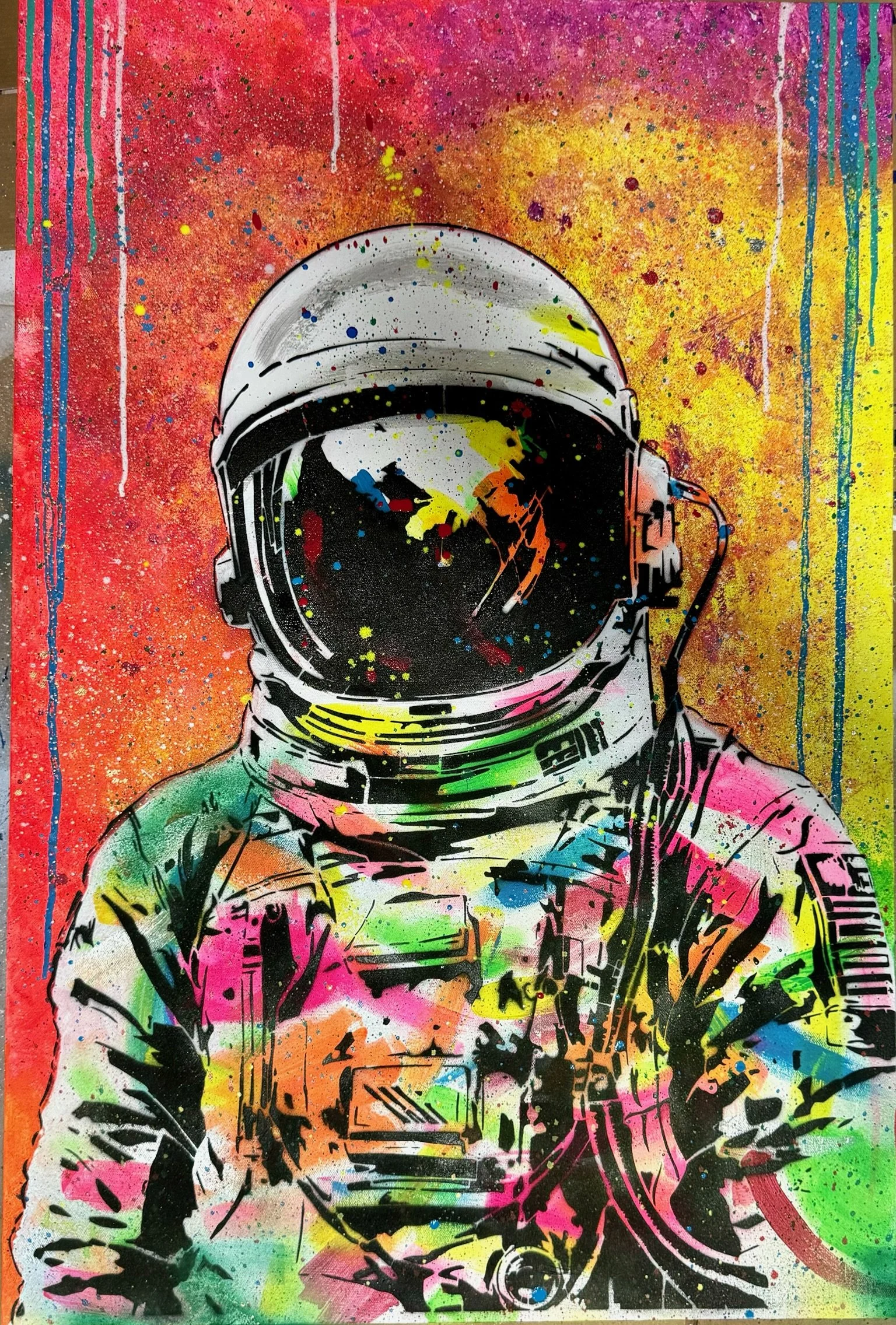 Street art painting of an astronaut in a colorful, splattered background.