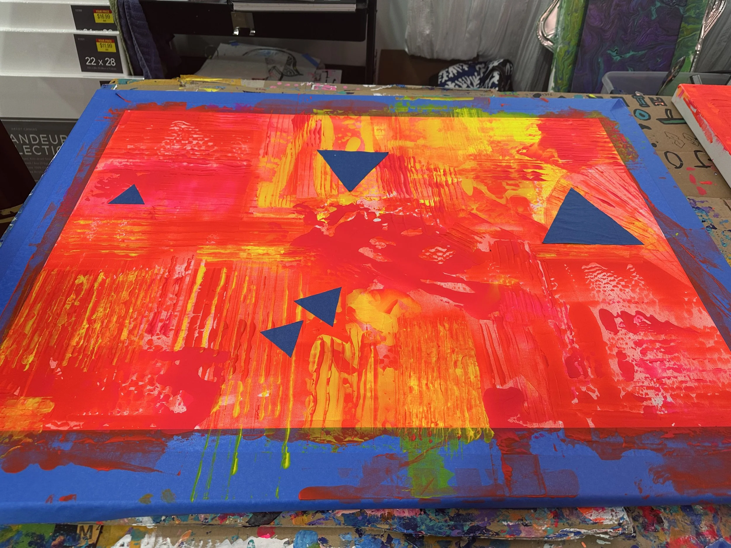 Abstract painting with bold red, yellow, and green strokes, and blue triangular shapes on canvas.