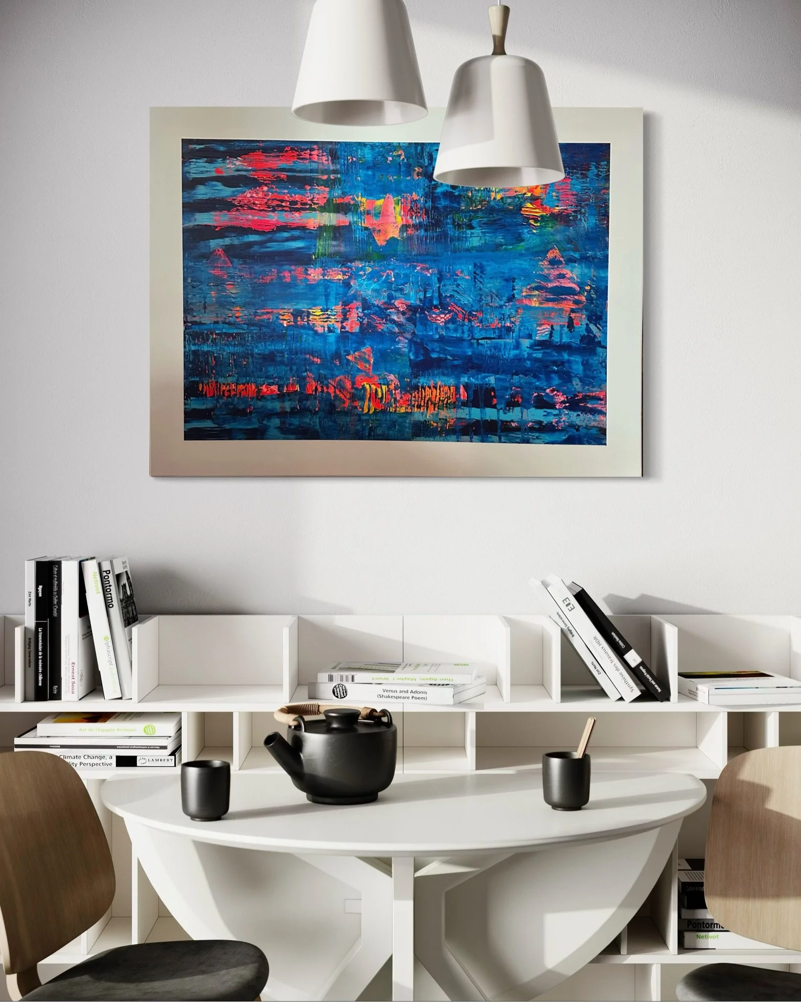 A modern white dining table with three black ceramic vases, a black teapot, and a black cup. Two wooden chairs are visible on either side. Behind the table is a white bookshelf filled with books, and above it hangs an abstract colorful painting. Two white pendant lights are suspended above the table.