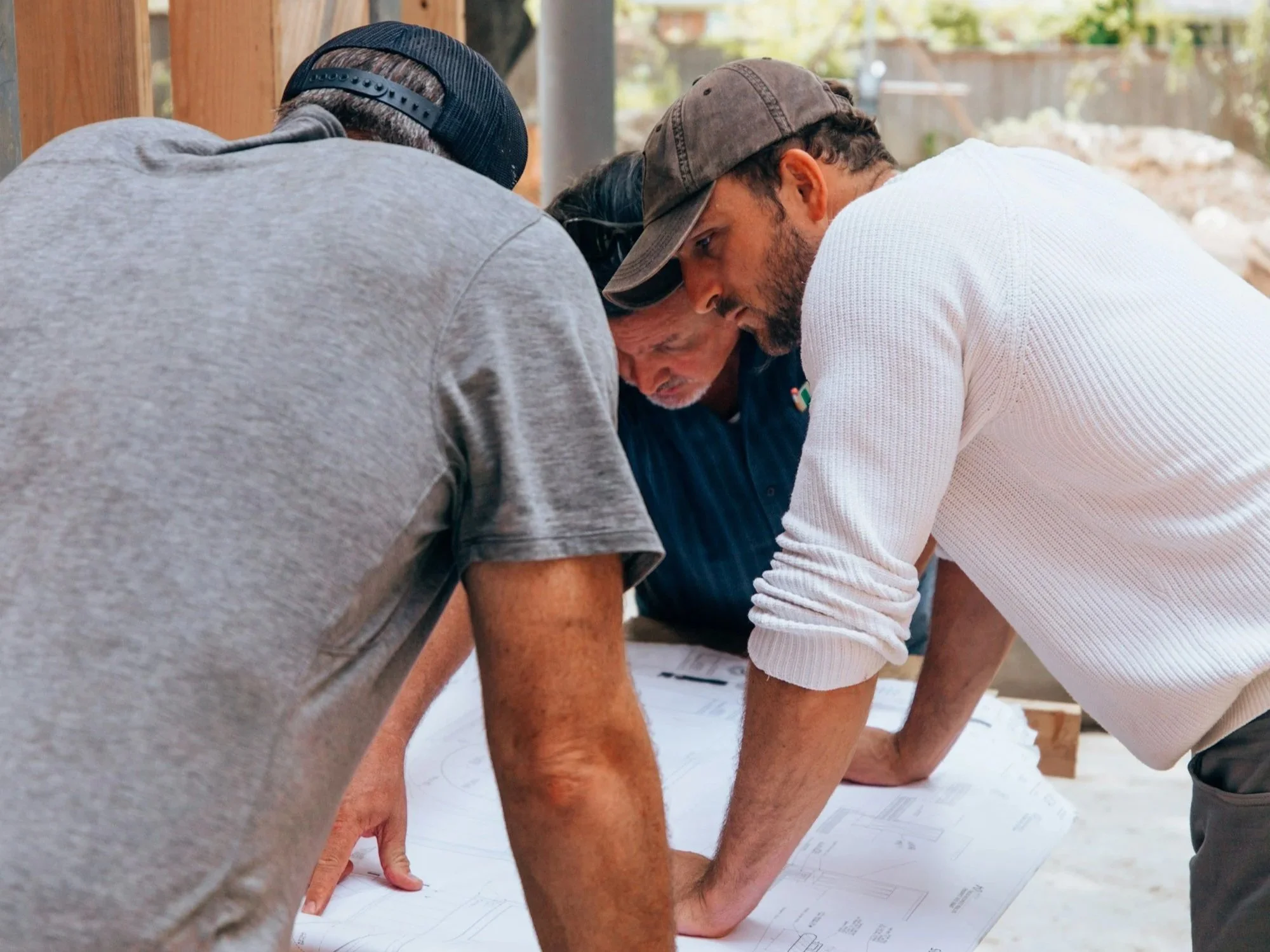 Project team reviewing architectural plans on-site before beginning a custom sheet metal installation.