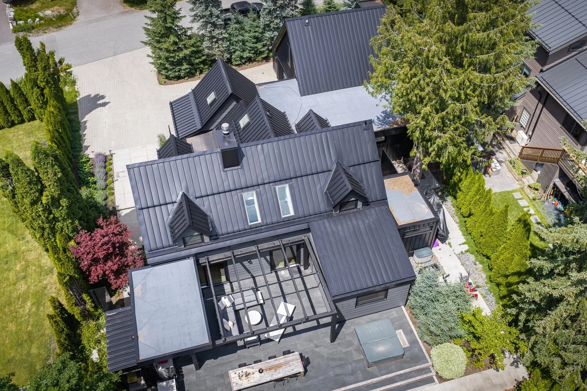 Aerial view of a custom home in Whistler featuring a standing seam metal roof designed for long-term performance.