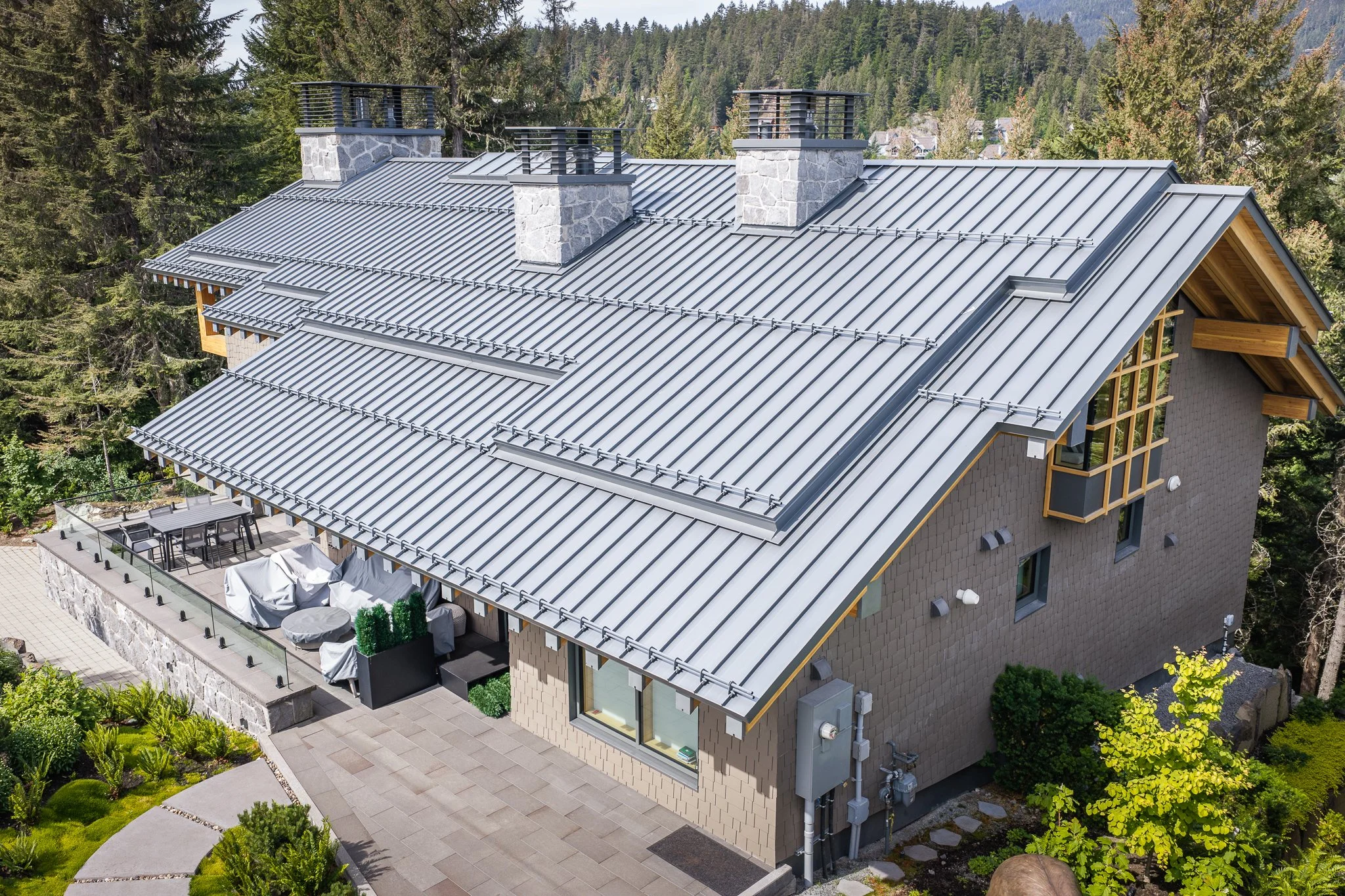 Aerial view of a custom mountain home featuring a standing seam metal roof installed by Wild Architectural Sheet Metal.