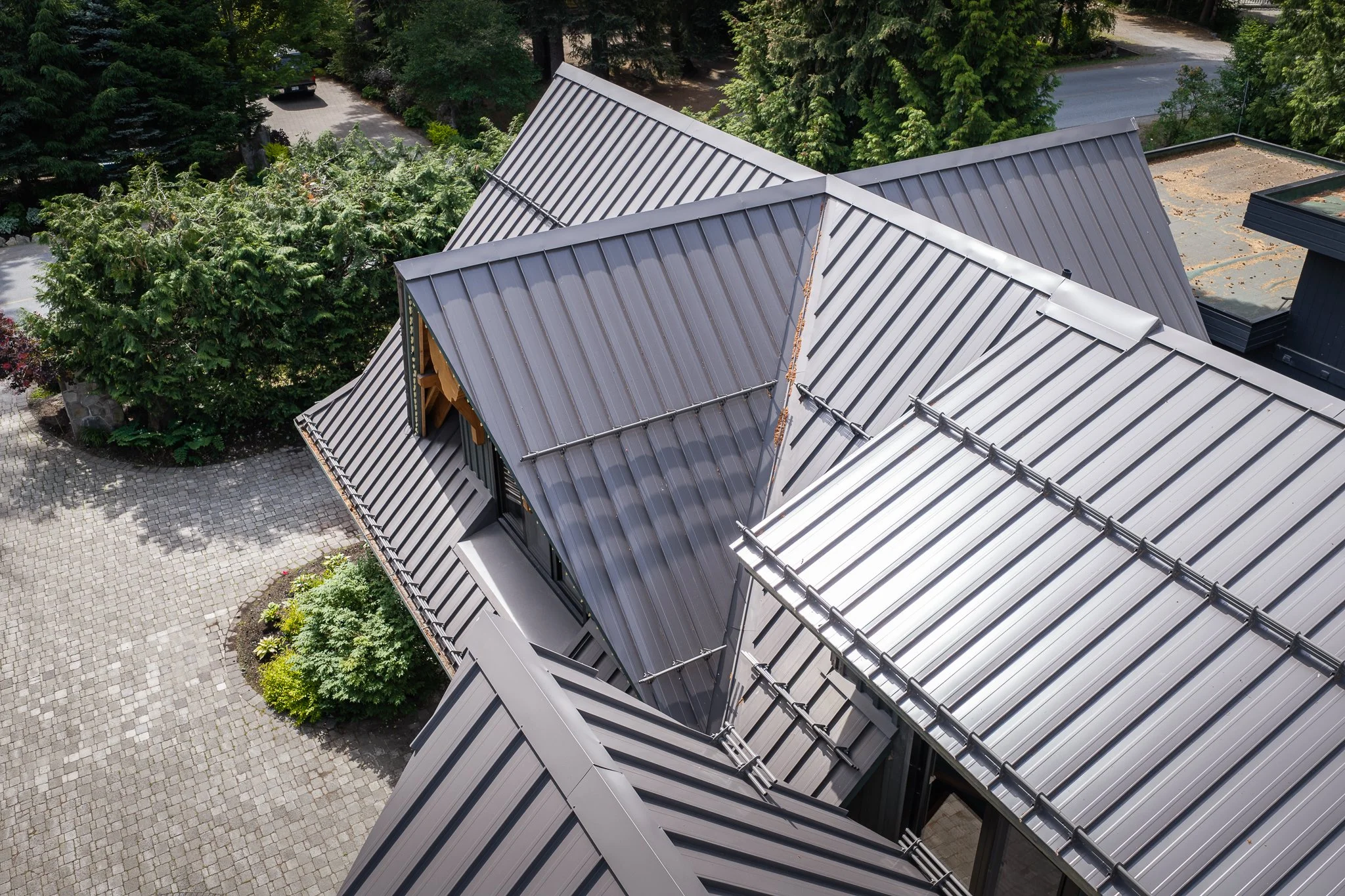 Aerial view of a standing seam metal roof installed on a custom home in Whistler, BC.
