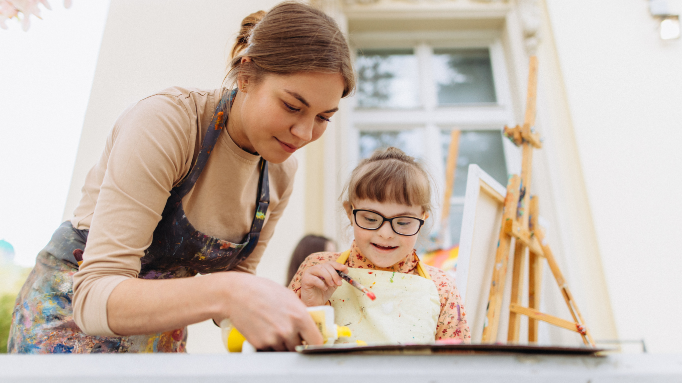 Caregiver and child painting together