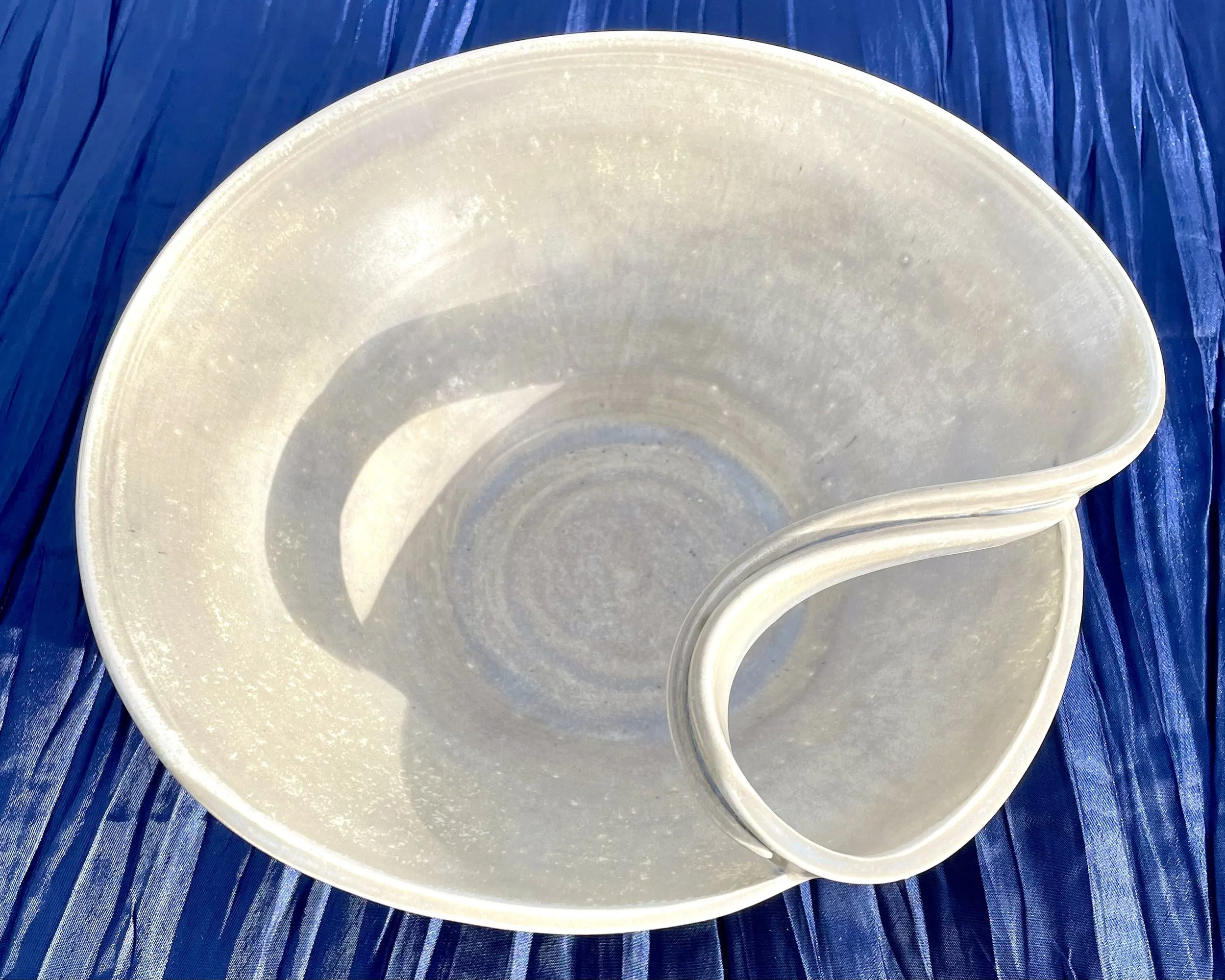 Multiple white disposable bowls placed on a blue wooden surface.