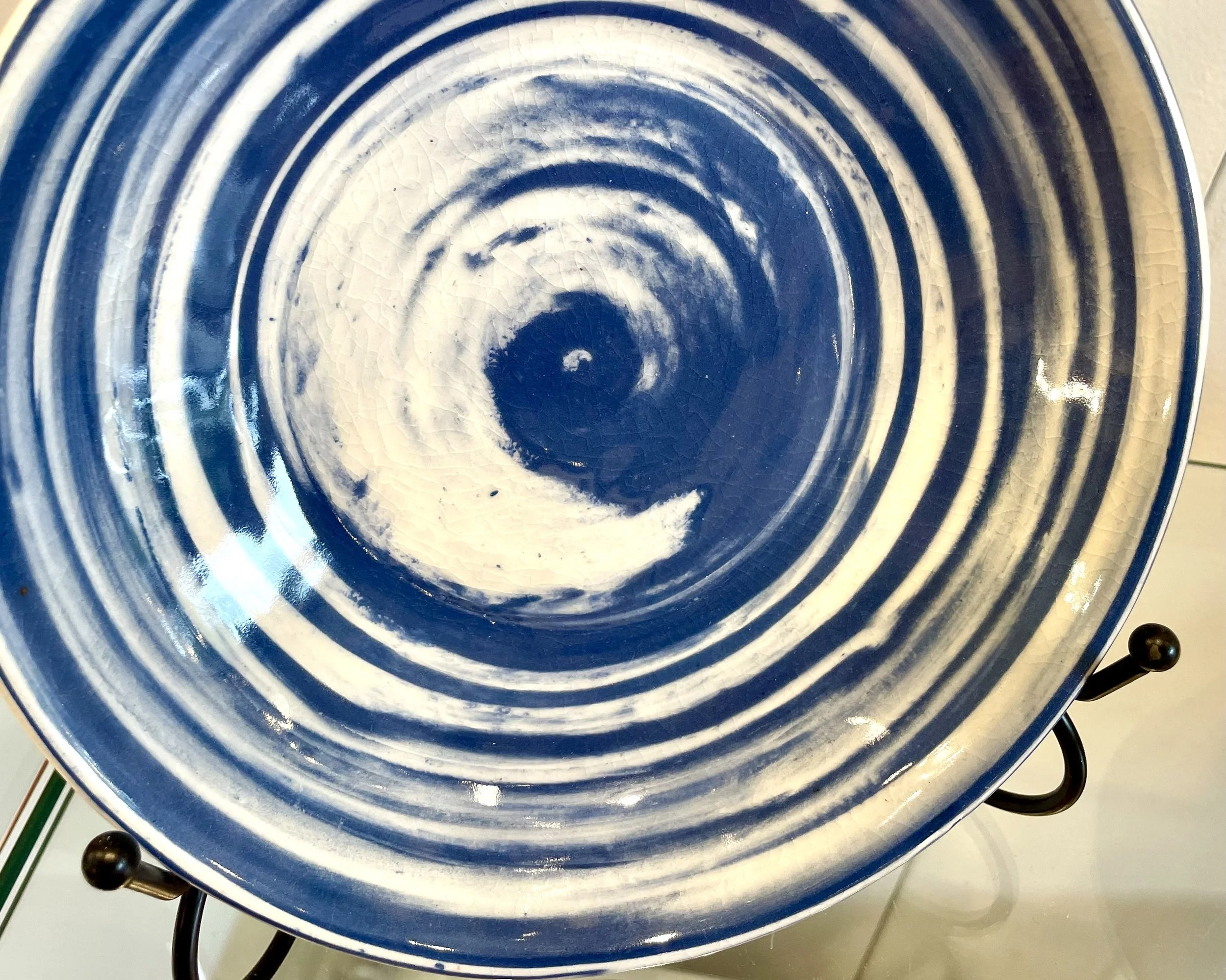 Blue and white spiral ceramic plate on a stove with black burners.