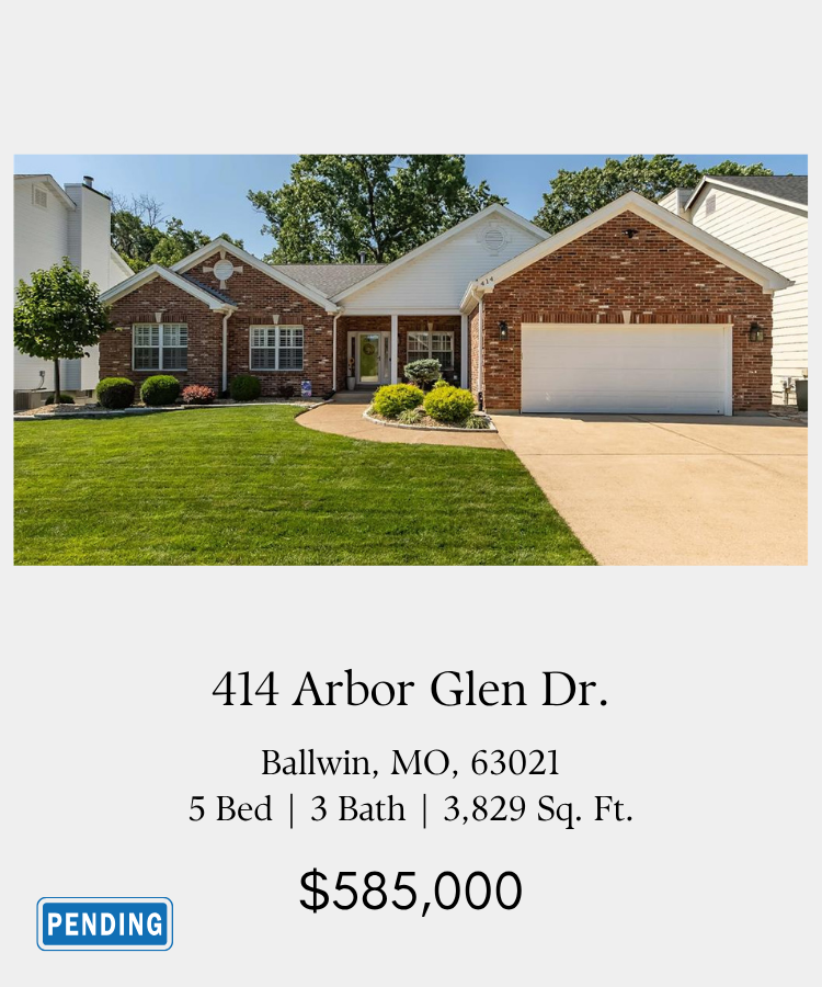 Front view of a brick and white house with a garage, green lawn, and landscaped bushes, located at 414 Arbor Glen Drive, Ballwin, Missouri, listed for $585,000.