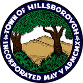 Seal of the Town of Hillsborough, North Carolina with a tree, a hill, and greenery surrounding the text.