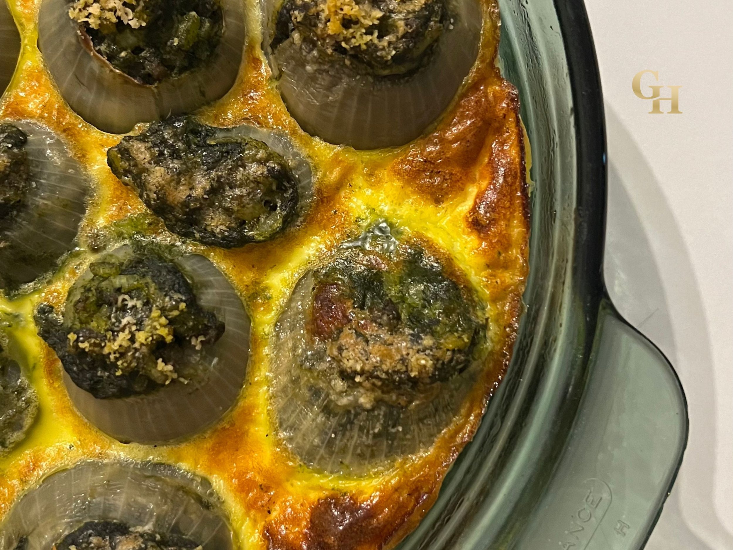 Baked stuffed zucchini boat with tomato sauce and cheese in a glass baking dish.