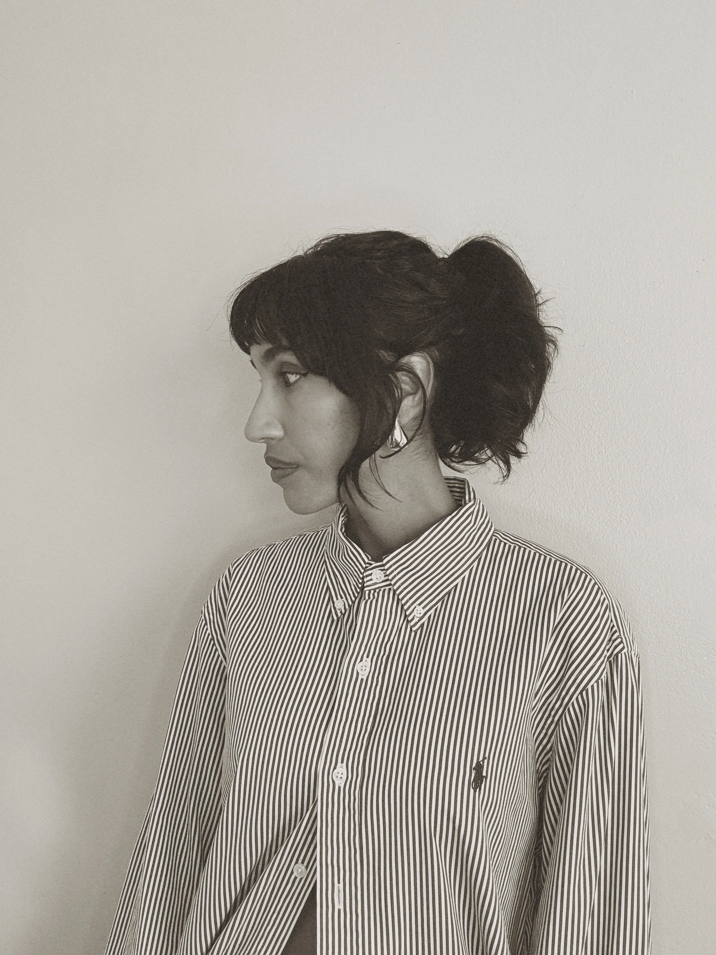 Profile portrait of Daniela Vargas, fashion and footwear designer, wearing a striped long-sleeve shirt