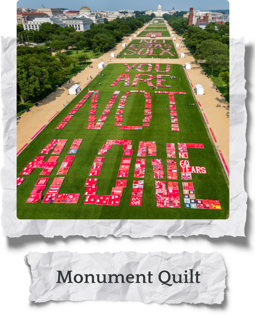 A large outdoor field with a message made of quilt blocks, reading "You Are Worth It." The message celebrates 60 years, with additional quilt blocks spelling out "60 Years" and other supportive messages. Photo from Monument Quilt, an activism project