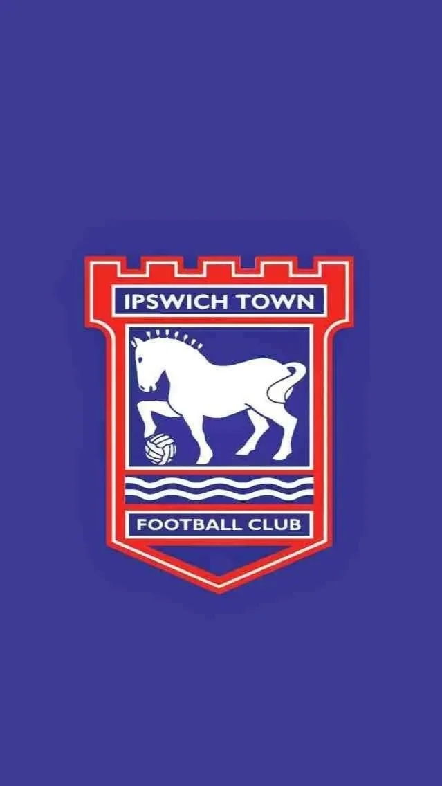 A crest for Ipswich Town Football Club featuring a white horse with a football under its hoof on a blue background, with red and white borders and text.