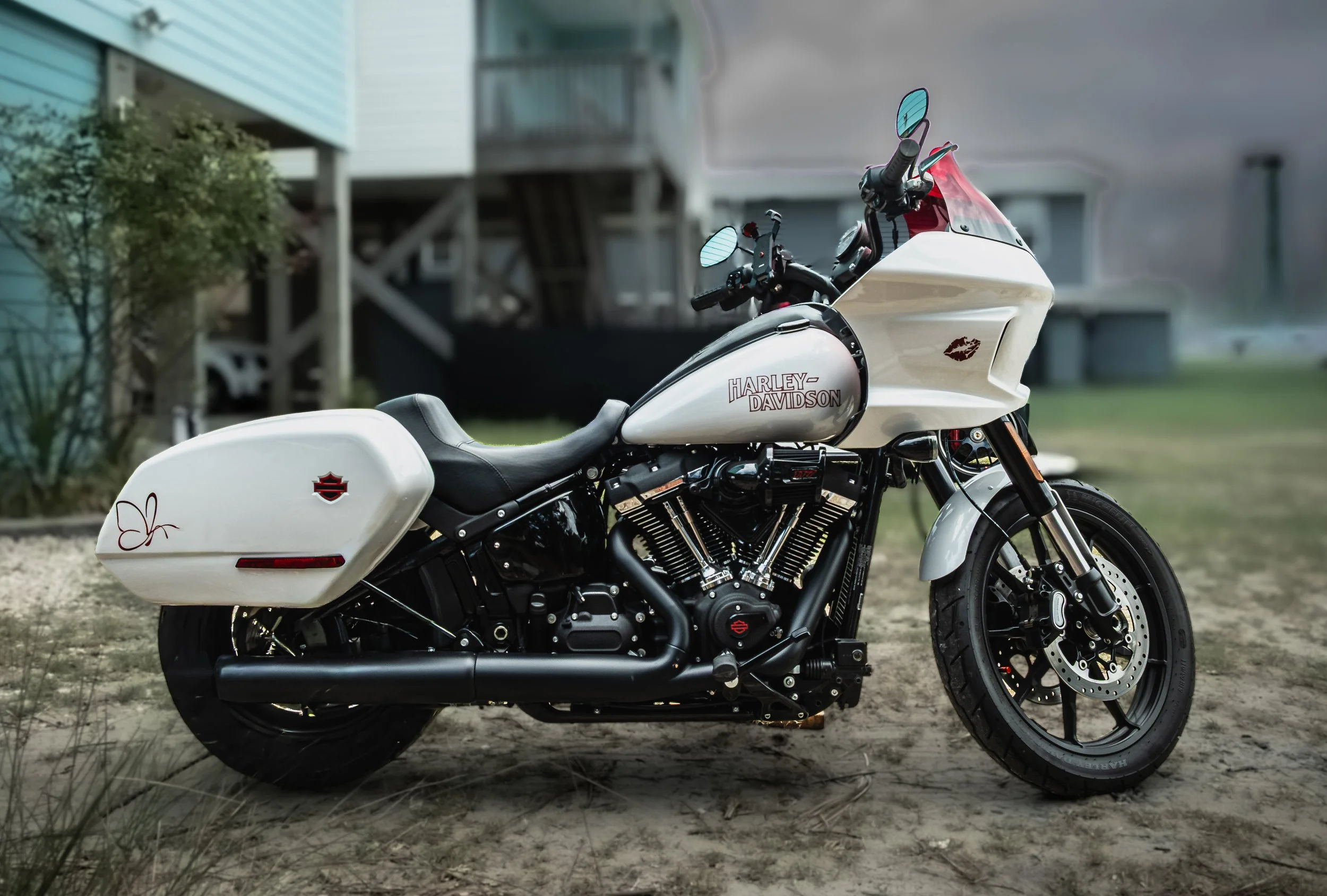 A white Harley-Davidson motorcycle parked   under a cloudy sky.