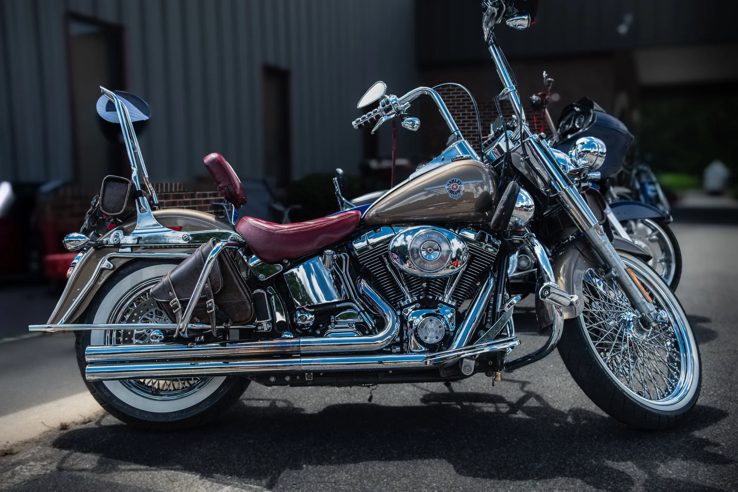 A shiny chrome Harley Davidson motorcycle with a red leather seat parked 