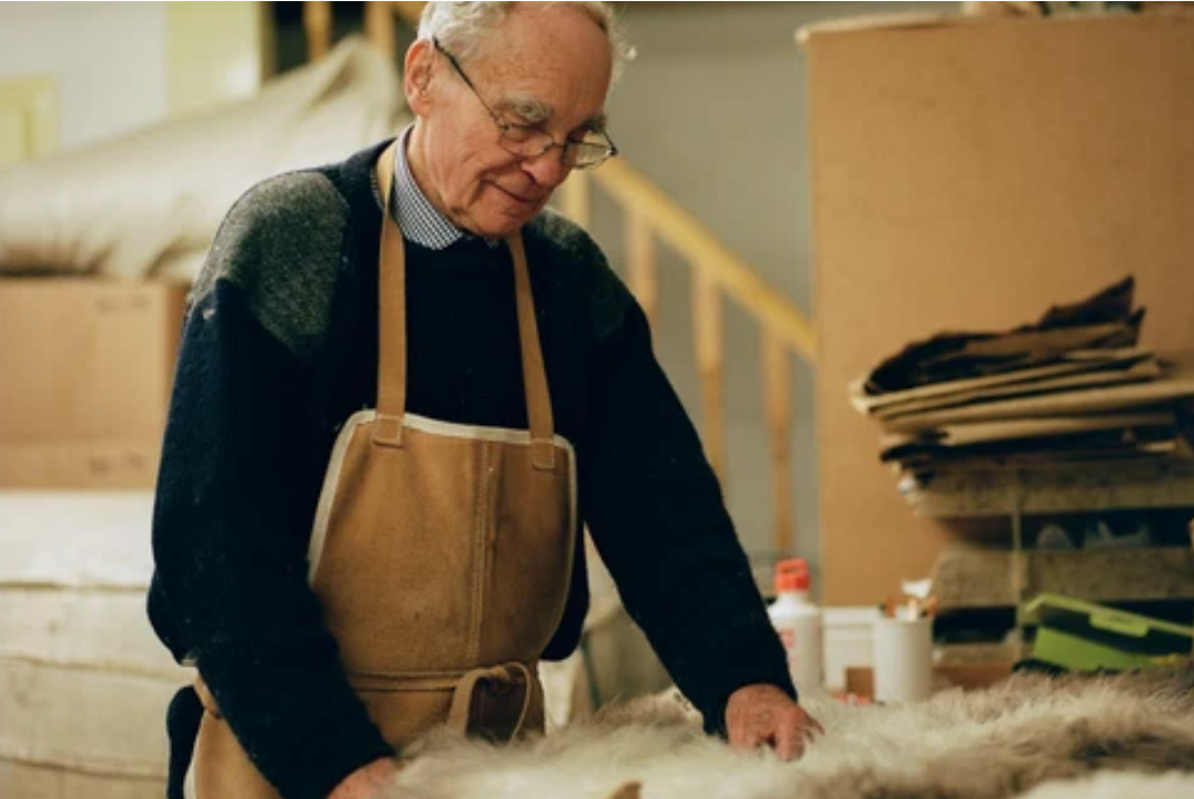 A skilled craftsman working on sheepskin rugs in a workshop