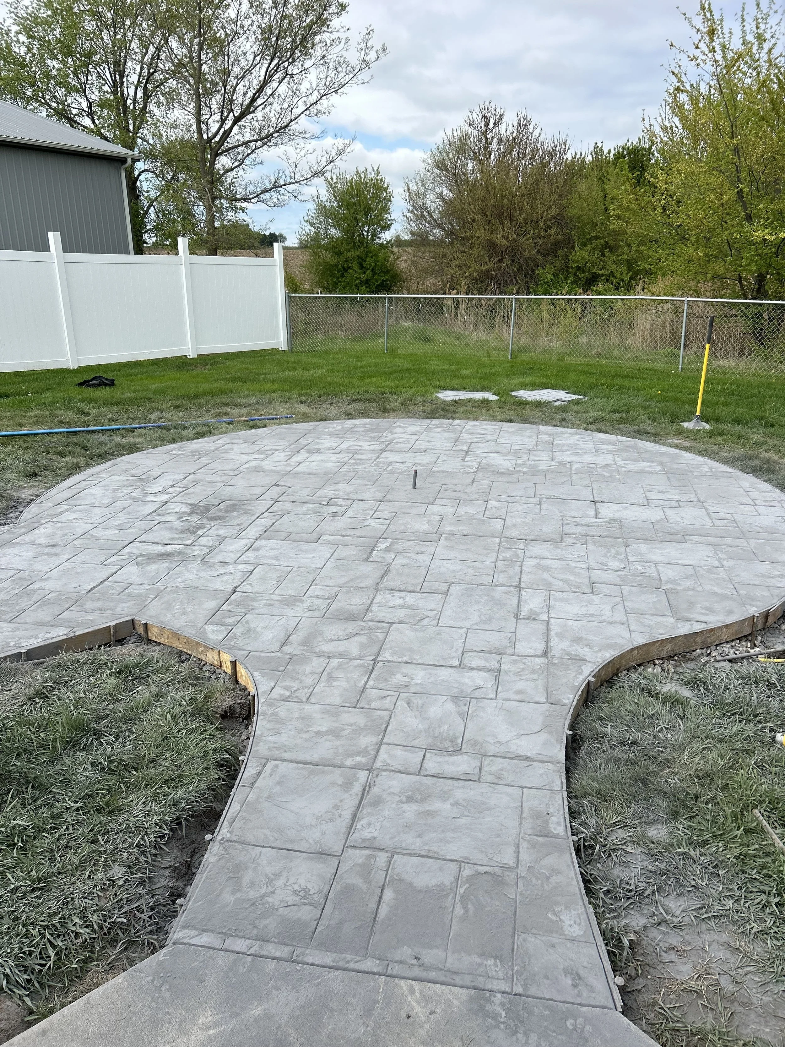 Constructed curved concrete patio with stamped stone pattern