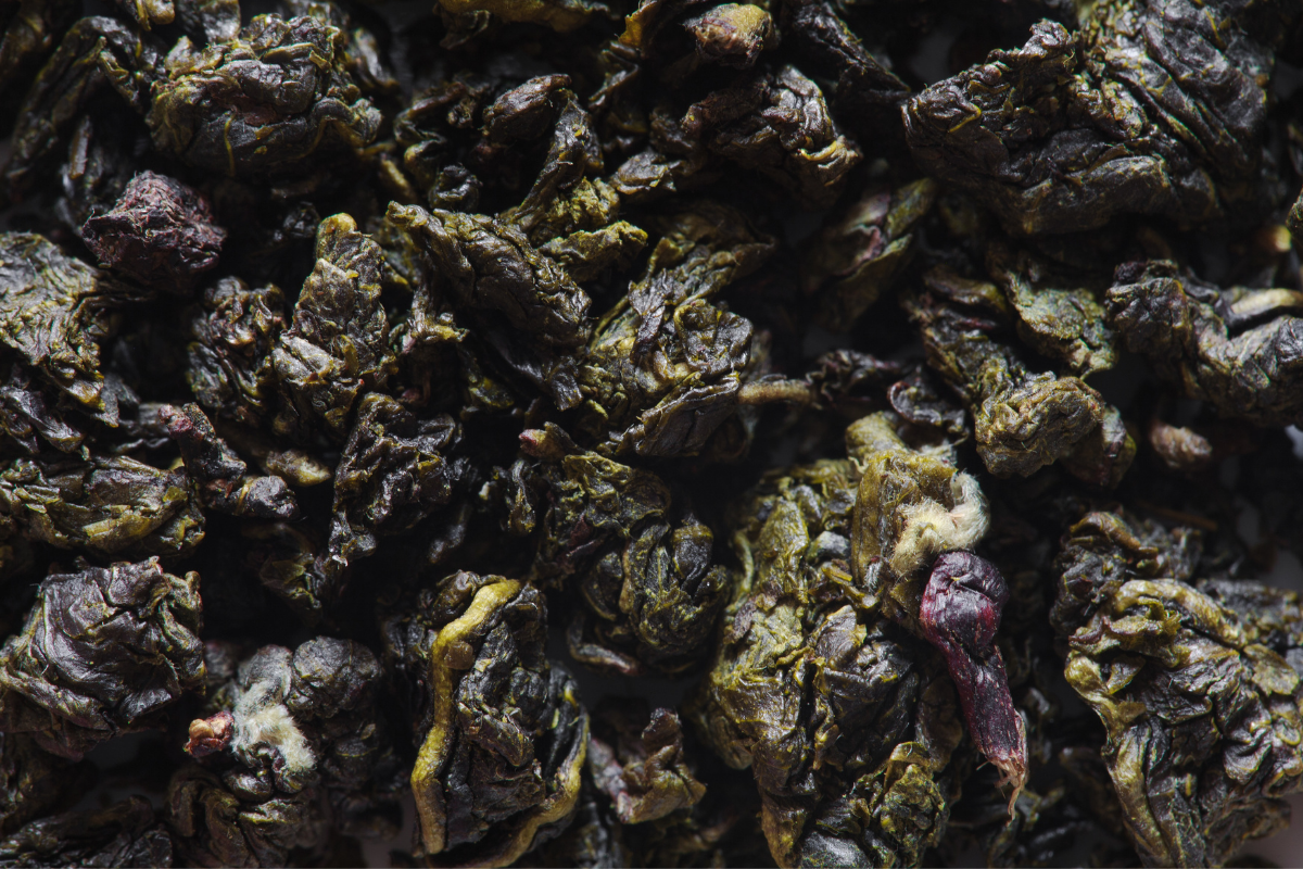 Close-up of dried, dark green tea leaves.