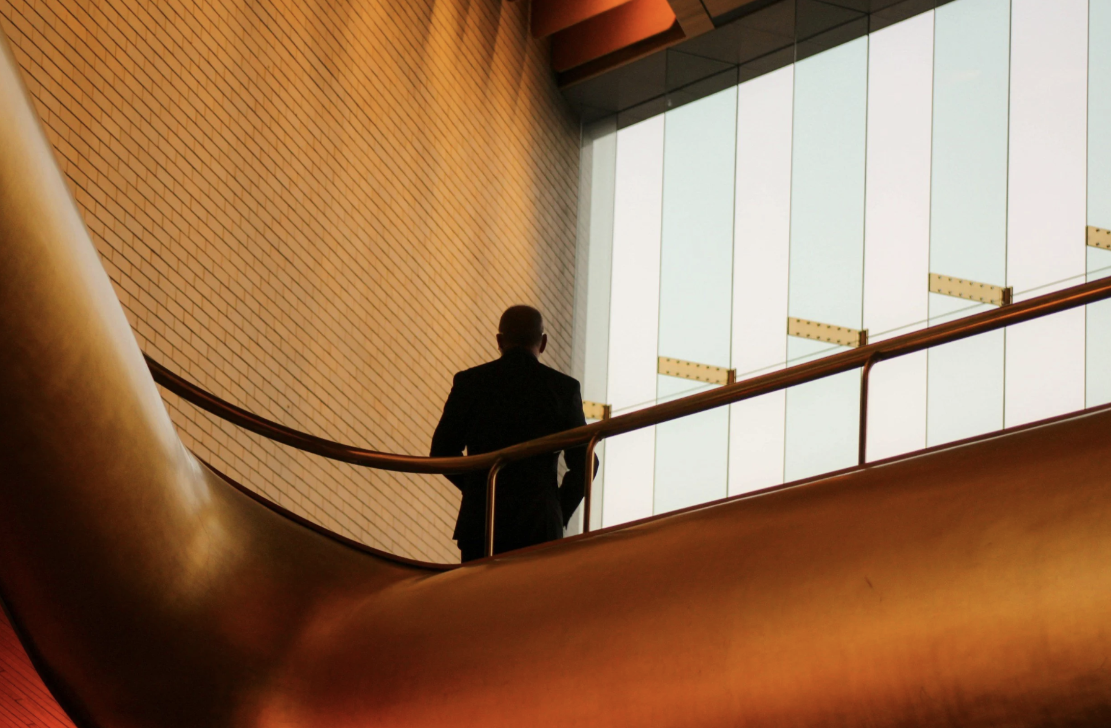 Lone entrepreneur standing at a window reflecting on being stuck despite knowing what to do — TOPT Method self-paced course for breaking through subconscious business blocks