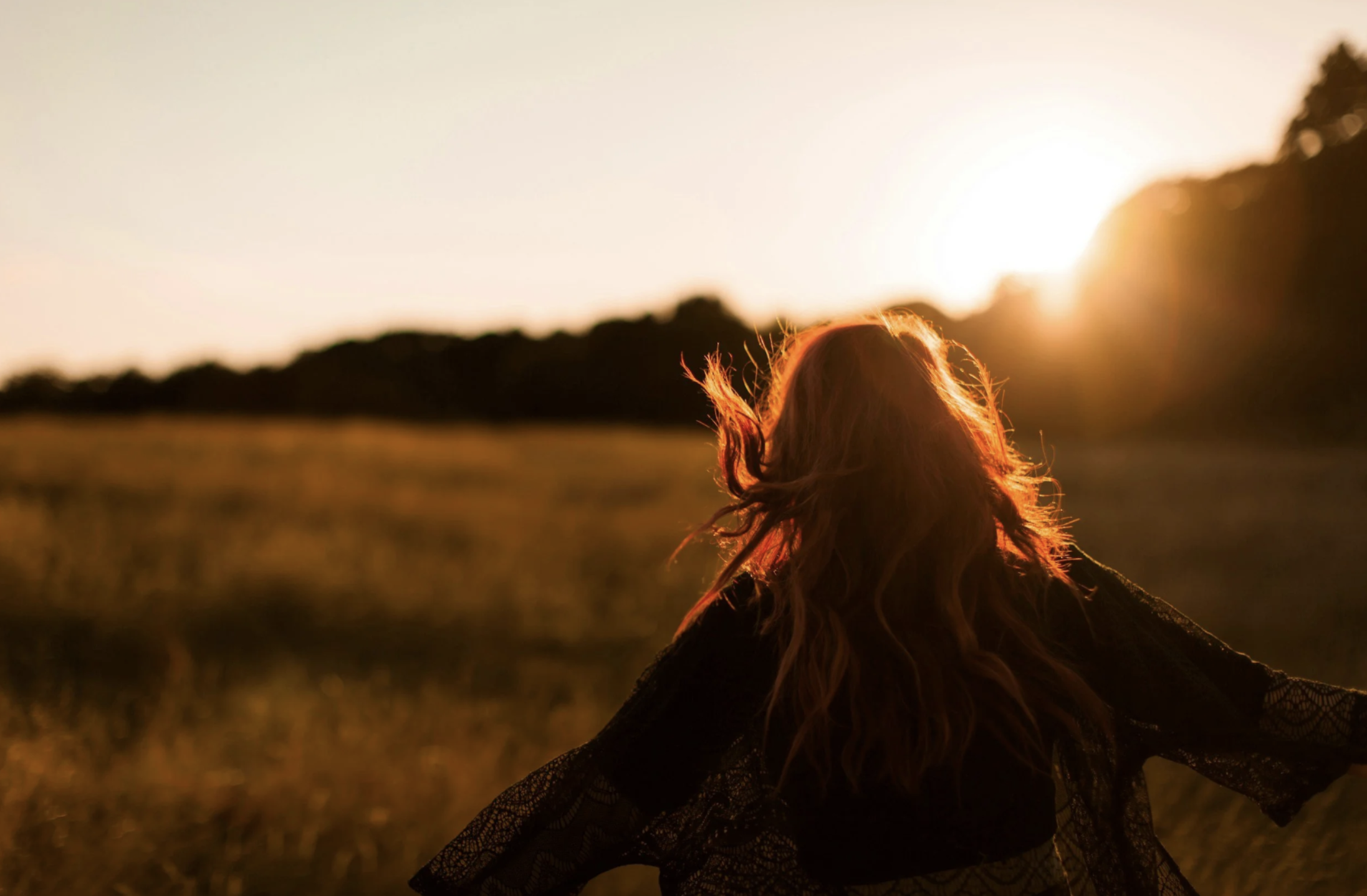 Entrepreneur woman looking toward the horizon at sunset, representing inner transformation and breaking through business plateaus