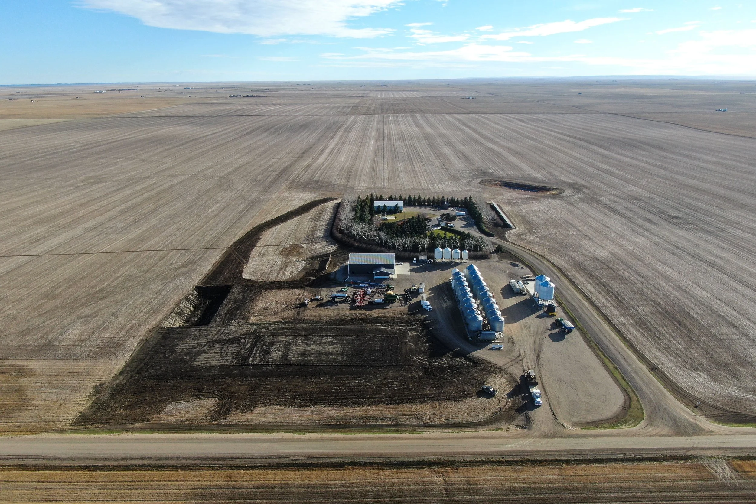 An aerial view of an agricultural bin yard that has been expertly landscaped using GPS Trimble technology, heavy equipment, resulting in proper land drainage.