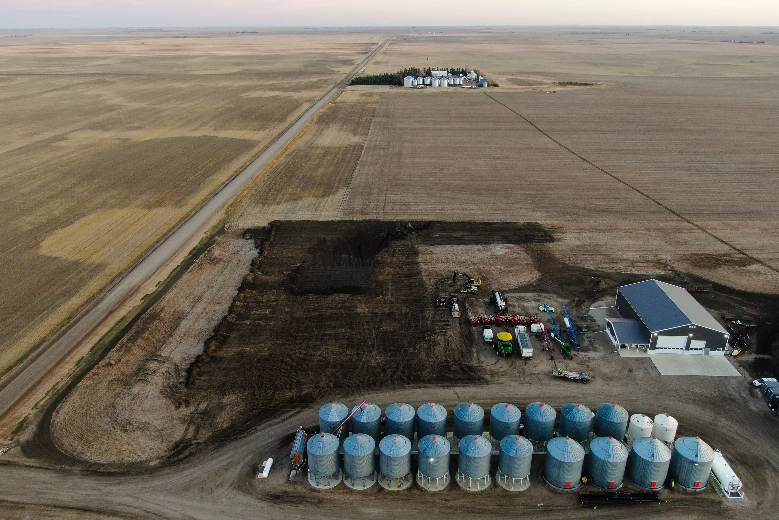 An aerial view of an agricultural bin yard that has been expertly landscaped using GPS Trimble technology, heavy equipment, resulting in proper land drainage.
