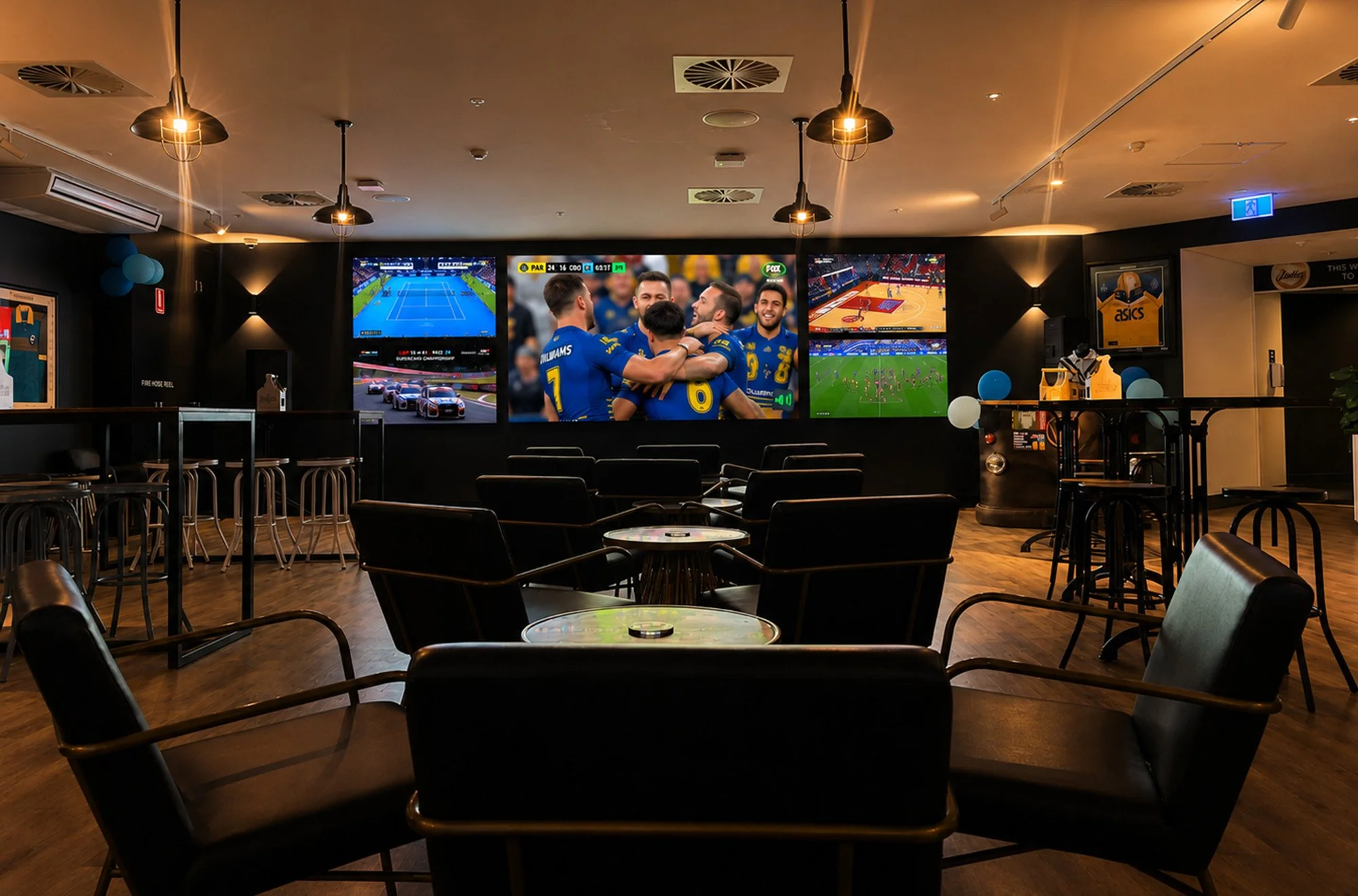 Bar or lounge area with multiple television screens showing sports videos, chairs, tables, and ceiling lights.