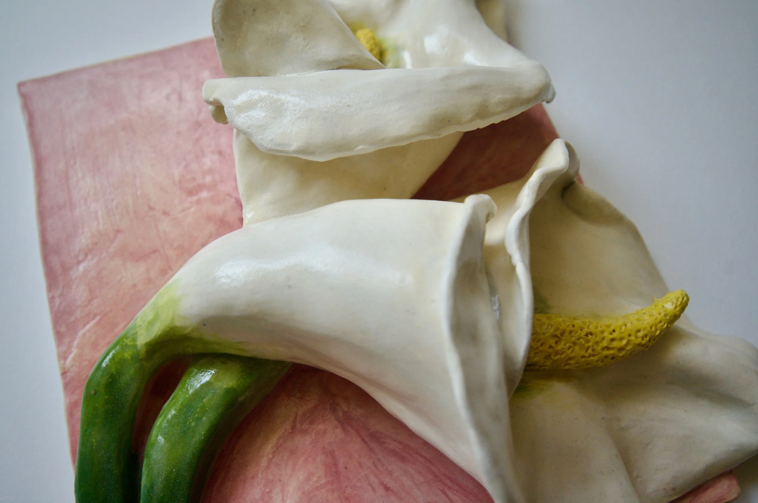 Close-up of a colorful abstract sculpture with pink, white, green, and yellow elements.
