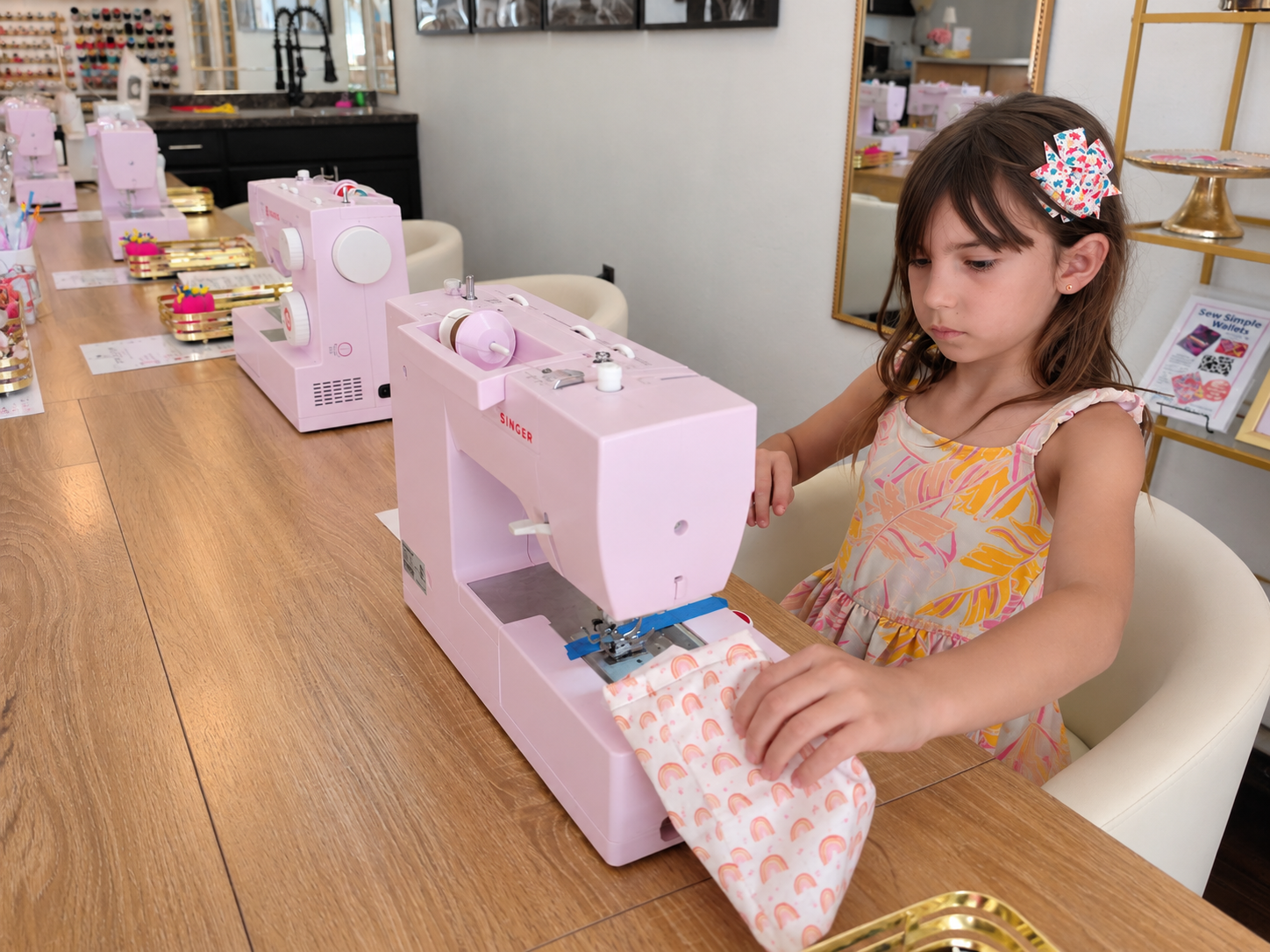 Kids use pink sewing machines to make pink floral and gingham drawstring bags.