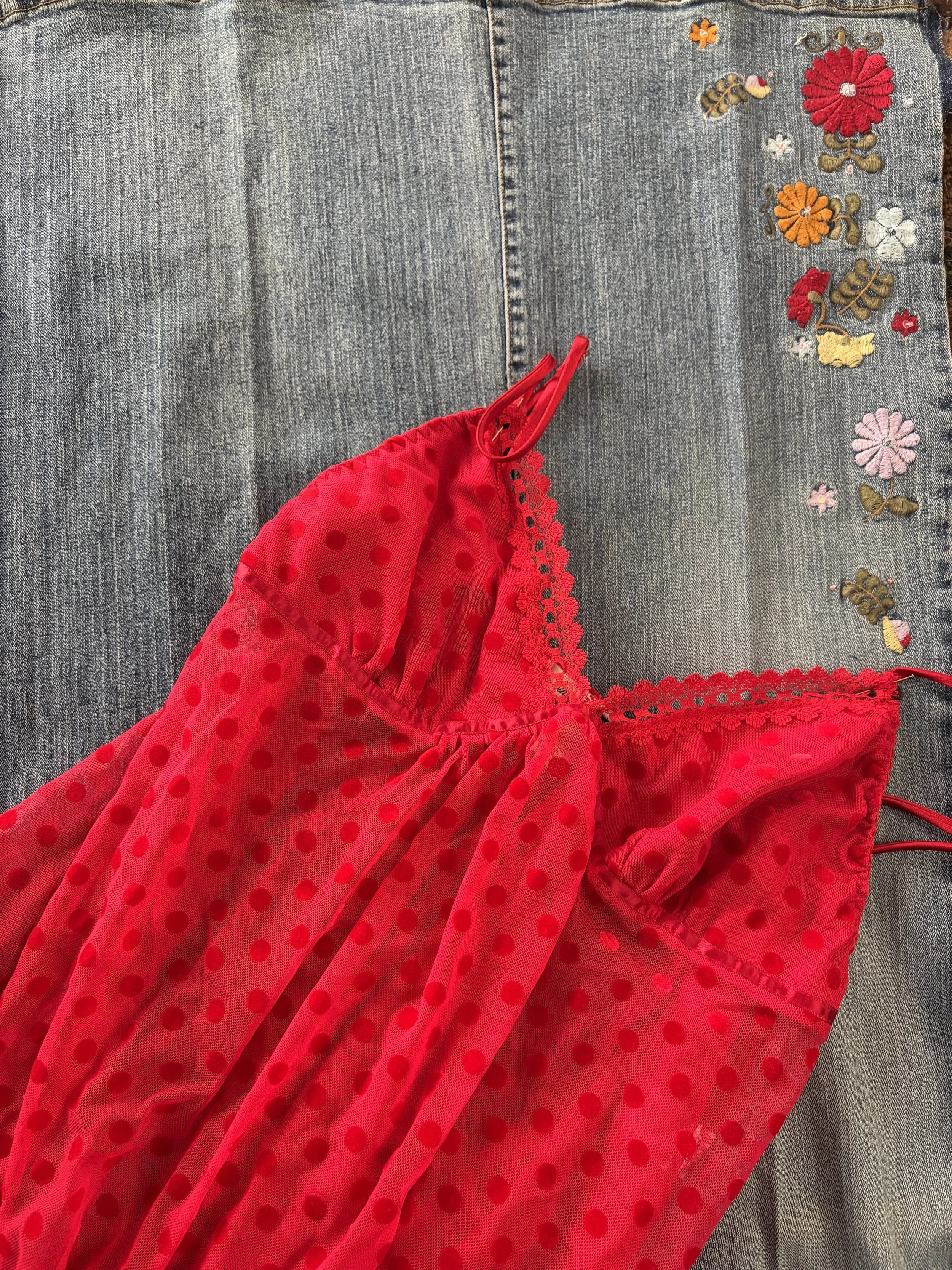 A close-up image of a denim skirt with colorful embroidered flowers and butterflies on the right side, and a red mesh fabric with polka dots and lace trim in the bottom left corner.