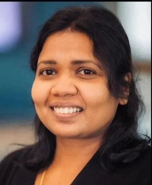Smiling woman with black hair in a professional setting.
