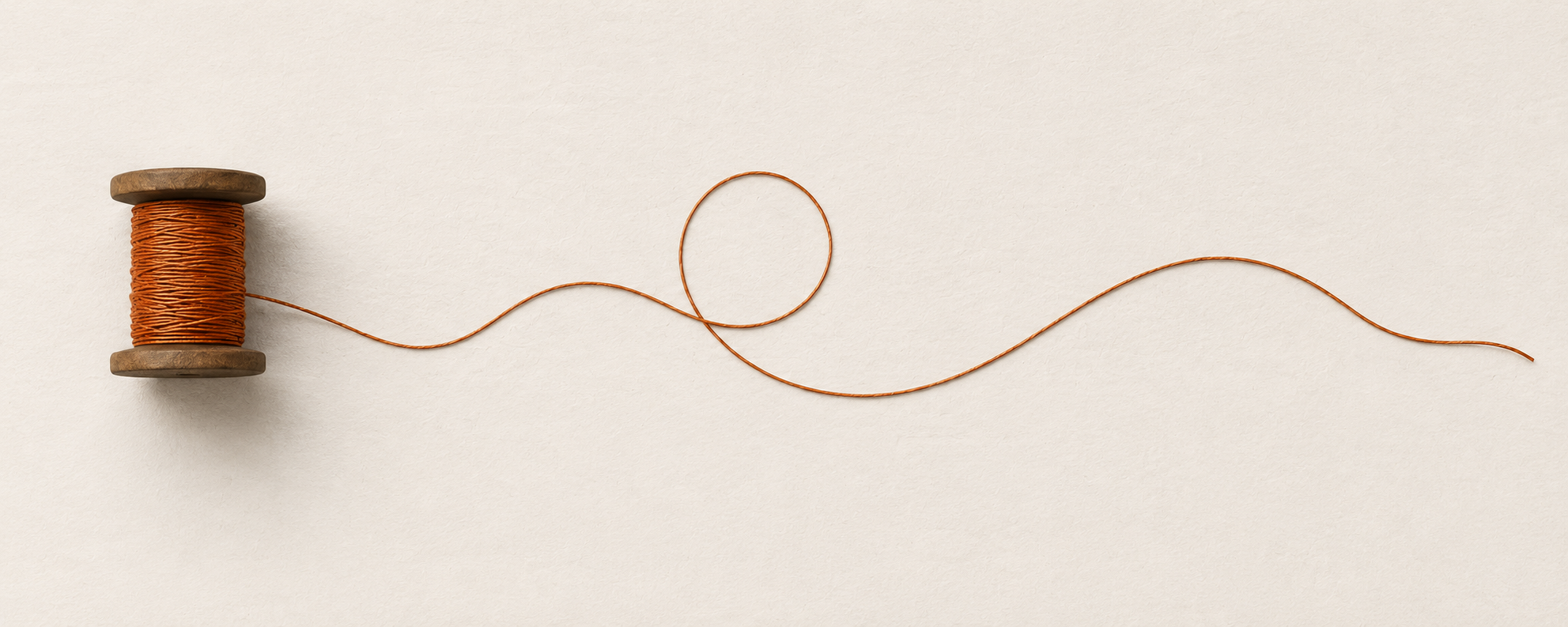 A vintage wooden spool with orange thread unwinding and forming a loose wave on a white background.